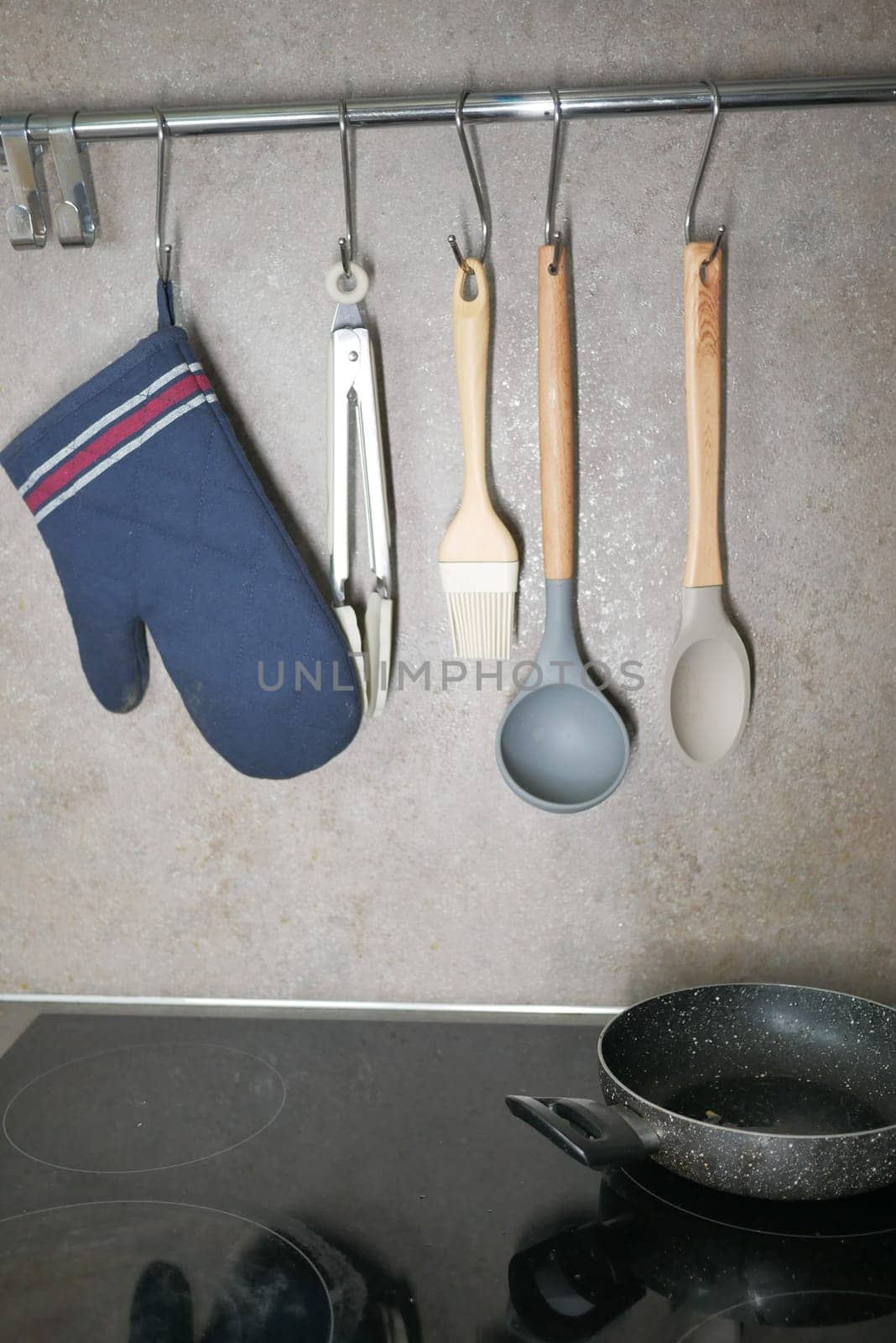 Kitchen utensils hanging on a hanger inside a modern kitchen, by towfiq007