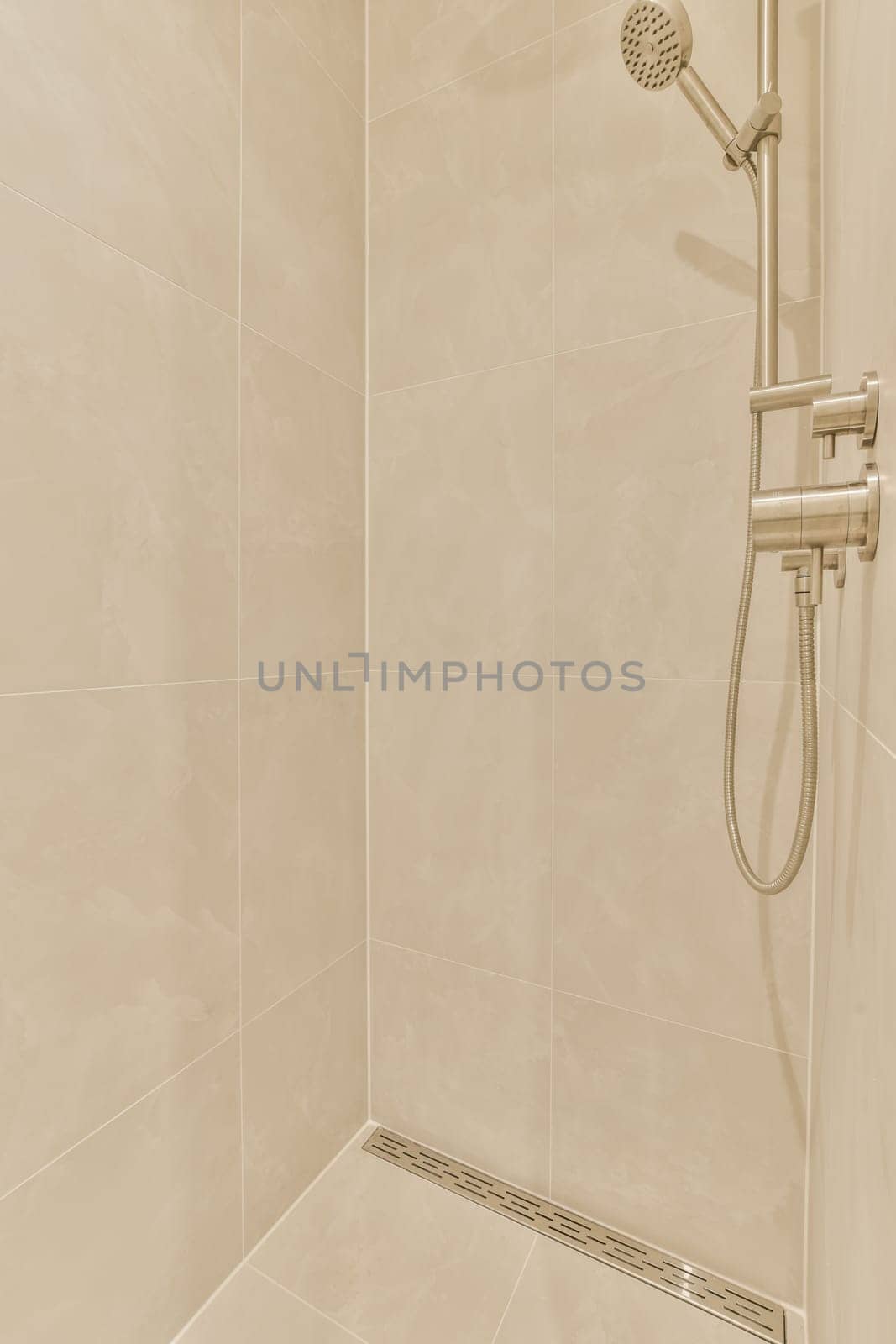a shower in a bathroom with beige tile walls and white tiles on the wall, there is an open shower head