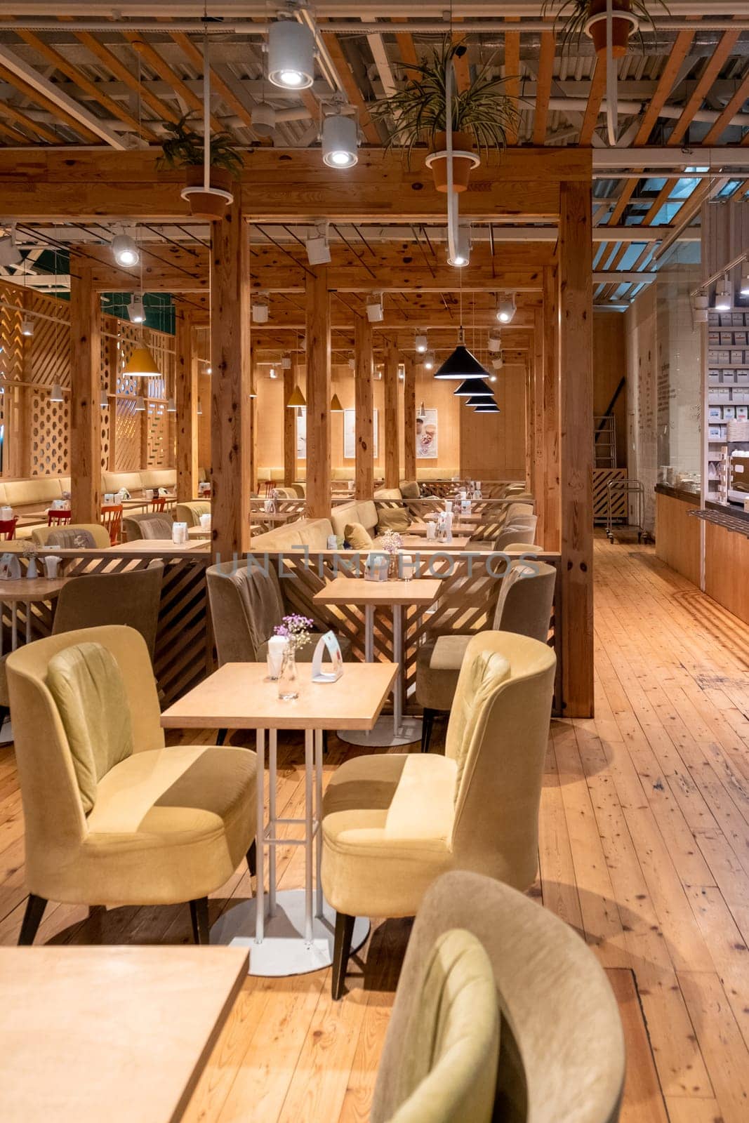 Loft style restaurant with textured wooden walls. Cafe restaurant in wooden style. There are plenty of tables with chairs and armchairs. Empty coffee without people.