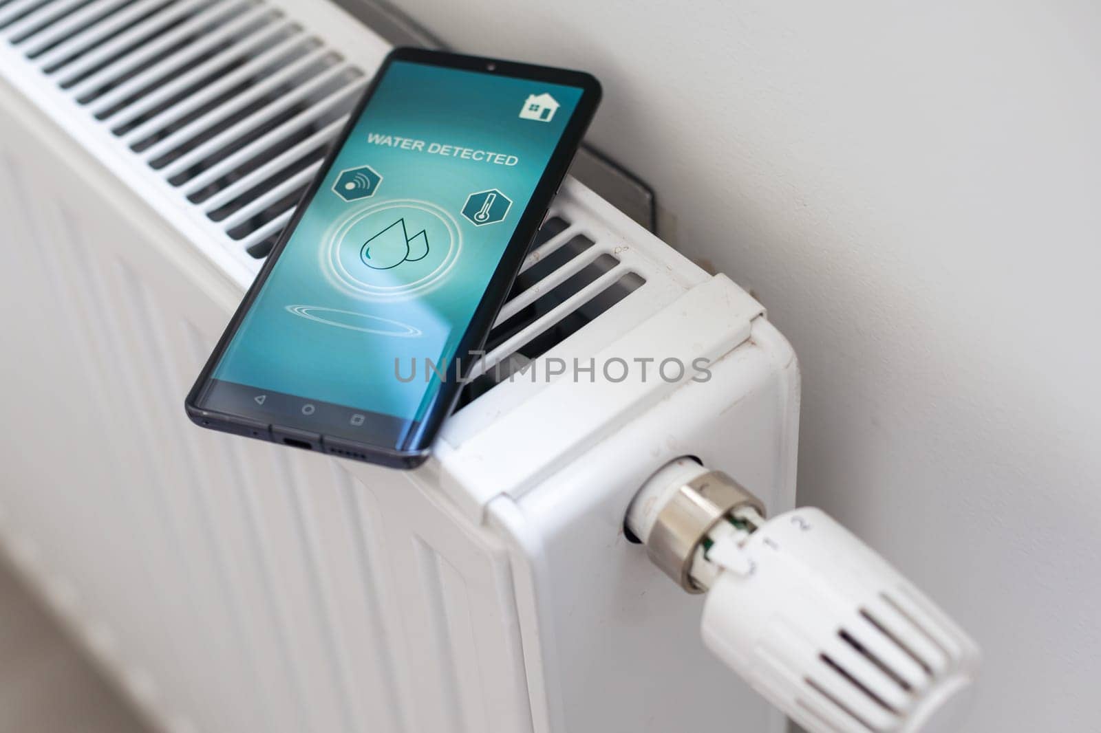 Smartphone with launched application for air temperature adjustment opposite the radiator. Health microclimate at home concept by Andelov13