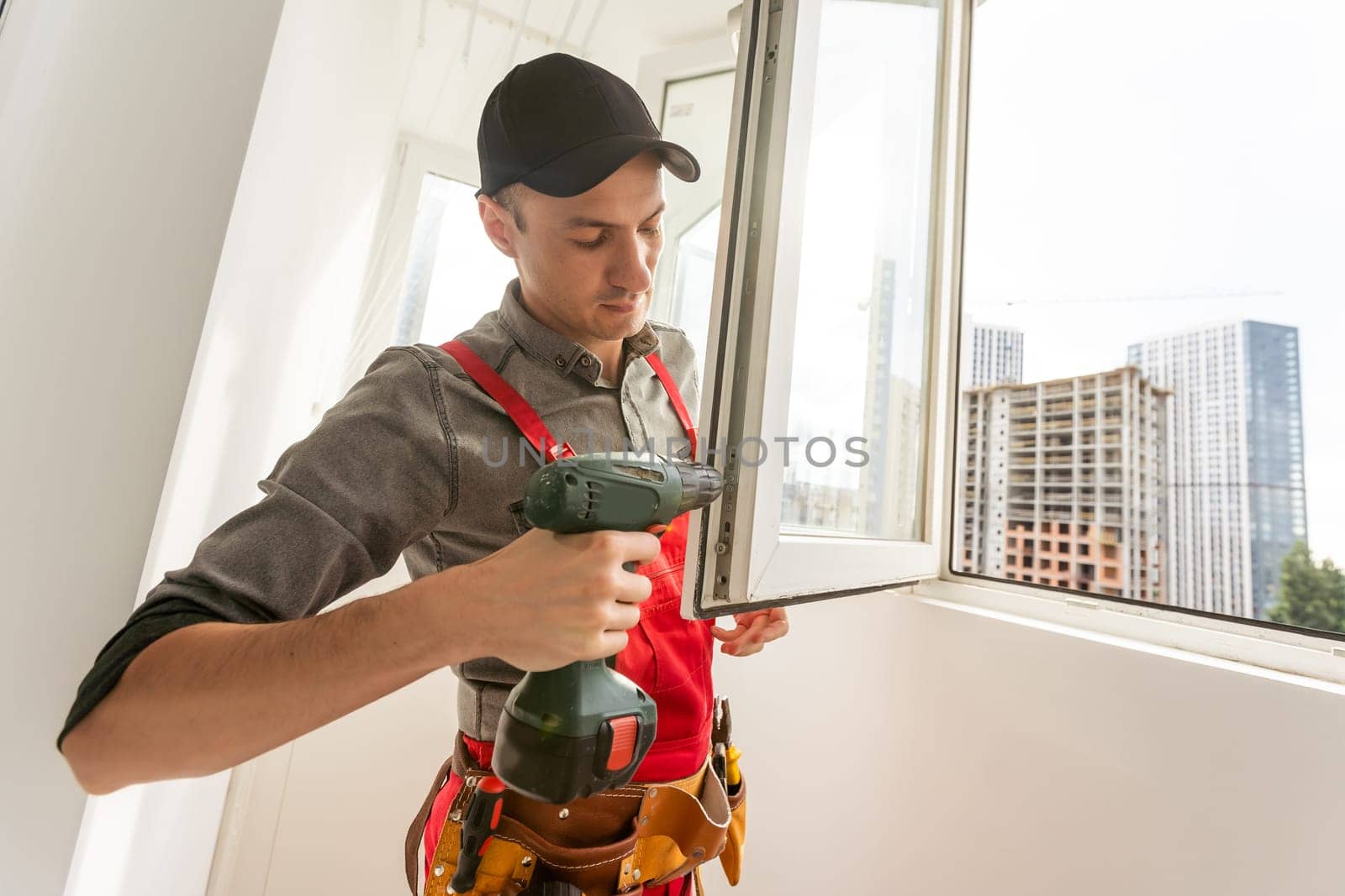 Young caucasians in uniforms working, clean up apartment, washing window. High quality photo
