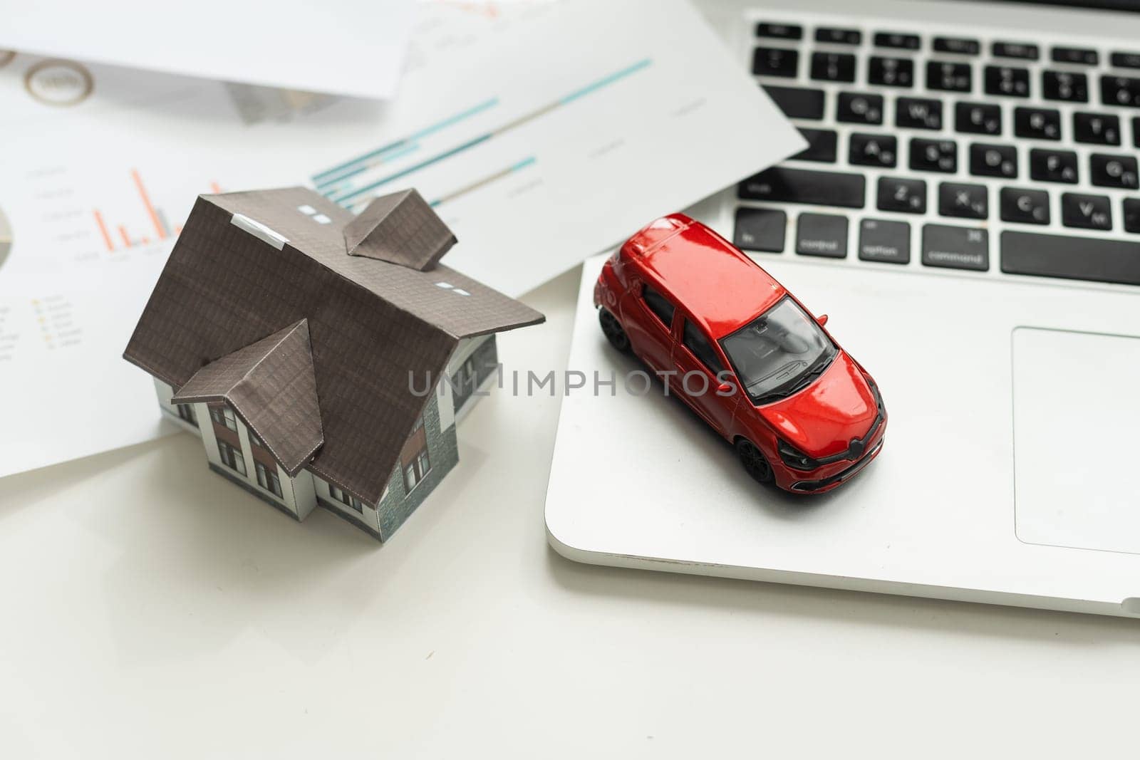 flat lay toy car, toy house, keys and money on the table by Andelov13