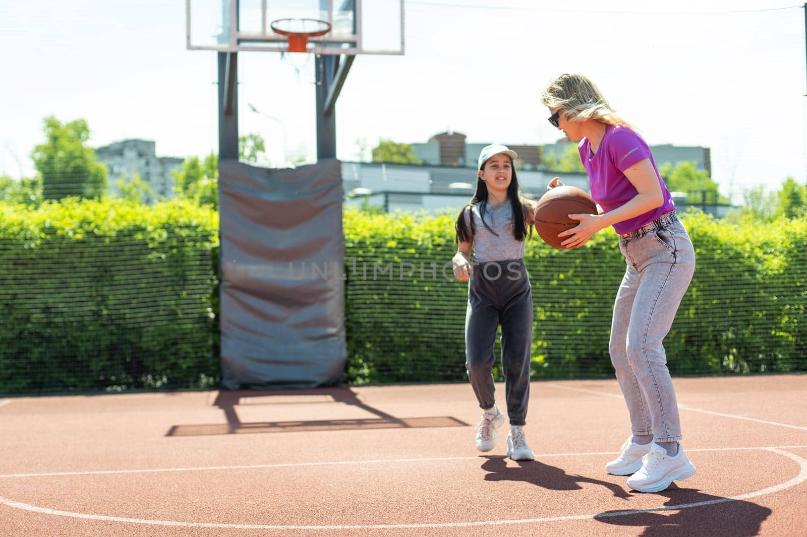 Mother and daughter playing basketball.