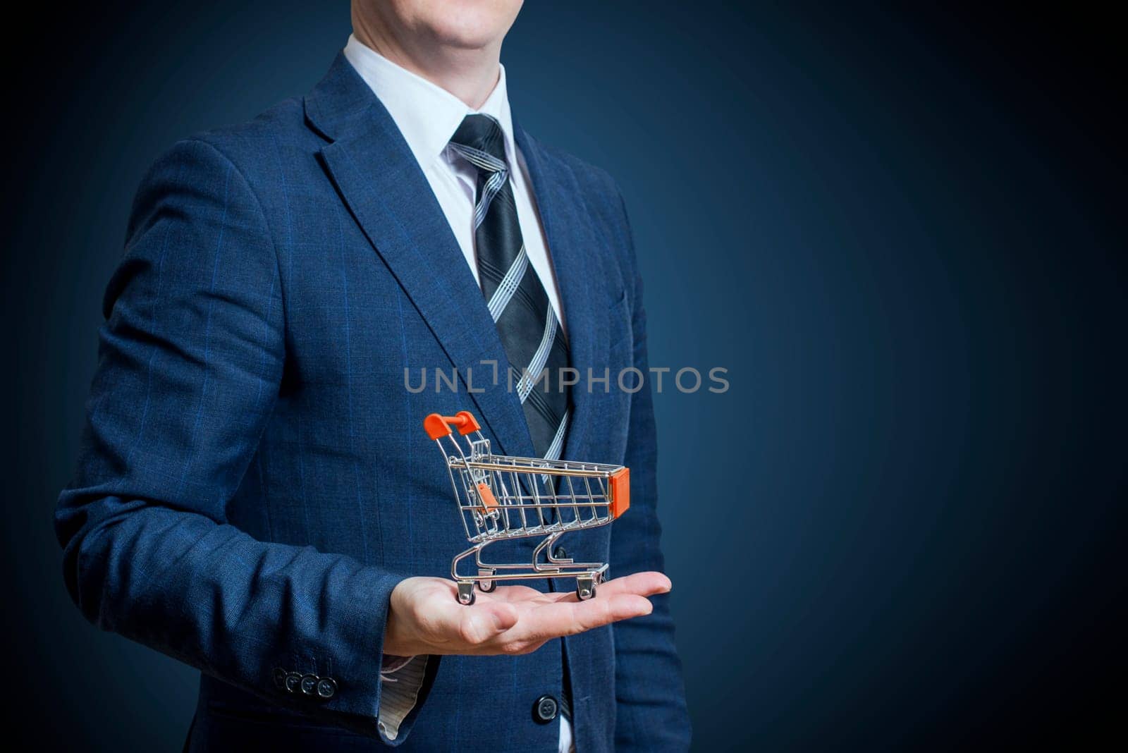 Businessman holding a shopping cart on his hand