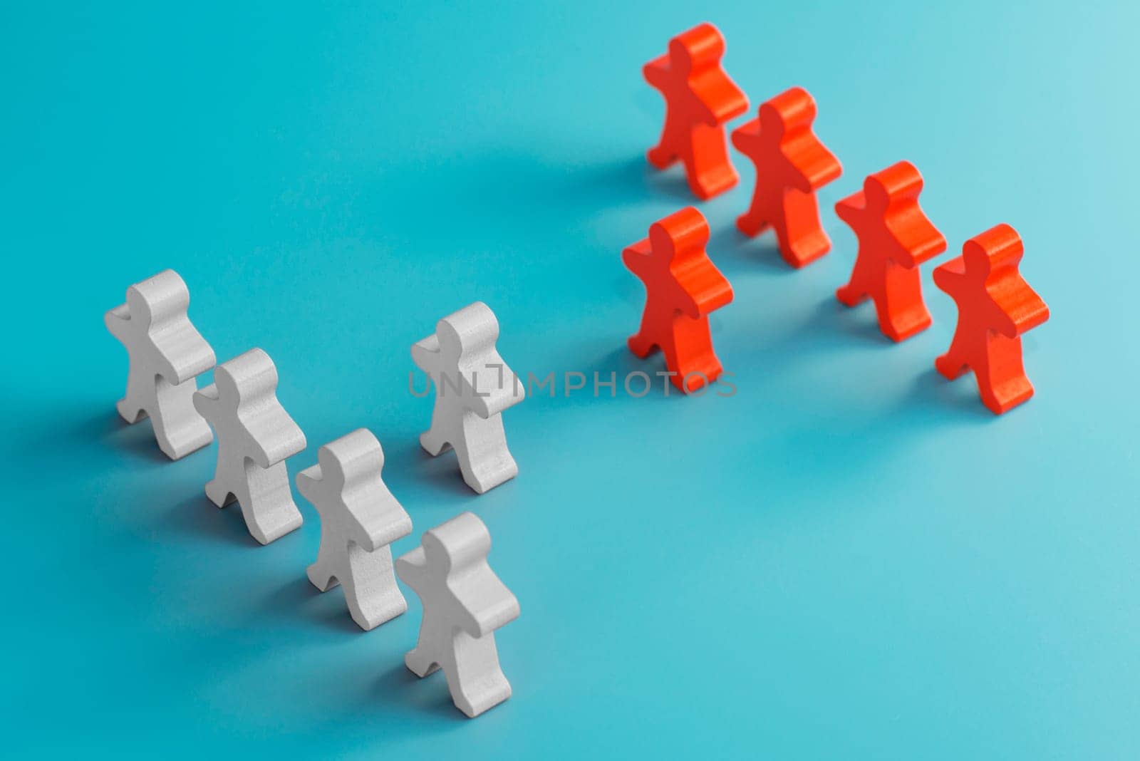 Two groups of wooden figures are standing in front of each other. Two groups of toy people in the discussion. Conflict of interest. Business competition. Candidates political debate.