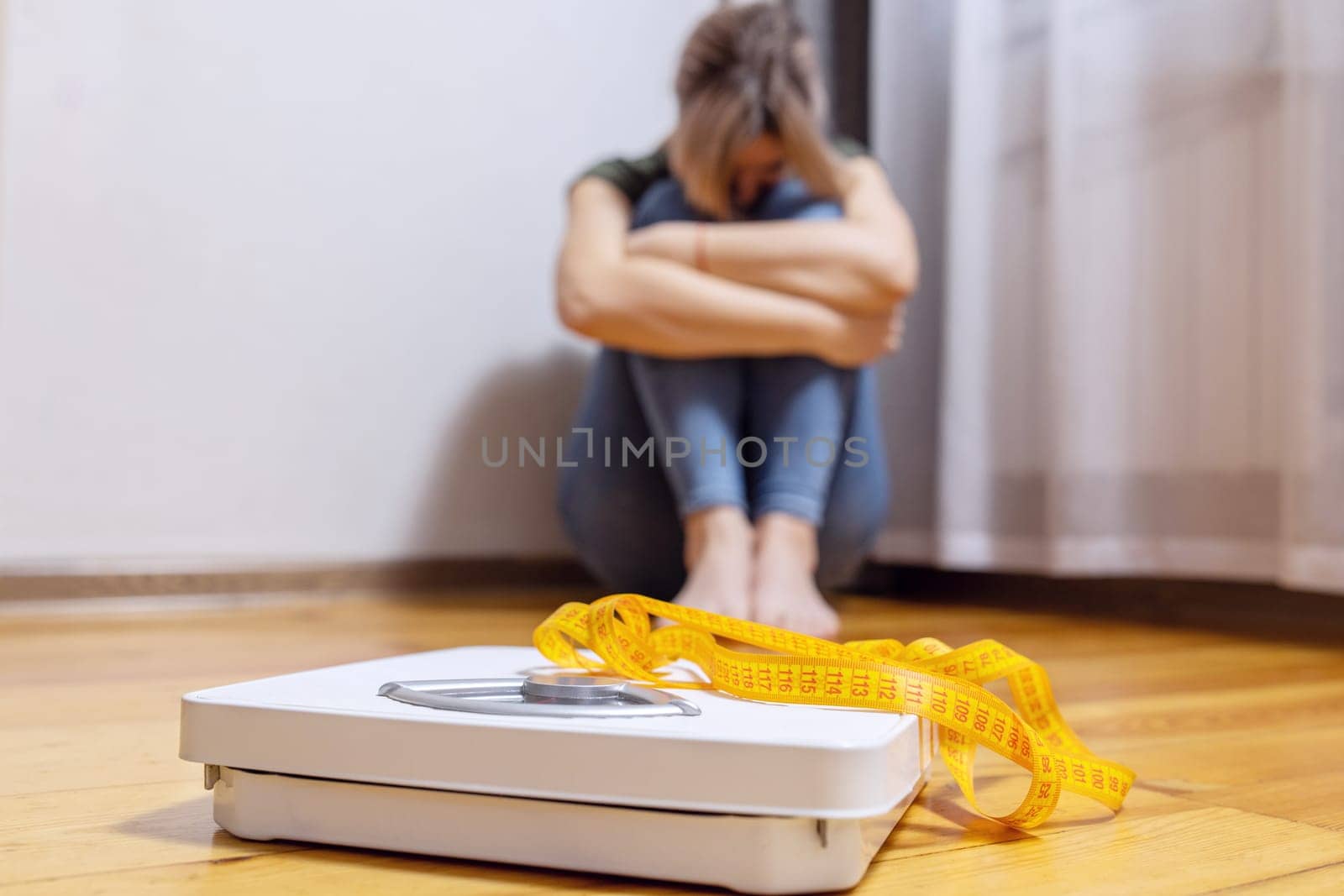 White scale and depression, upset and sad woman with measuring tape on wooden floor.