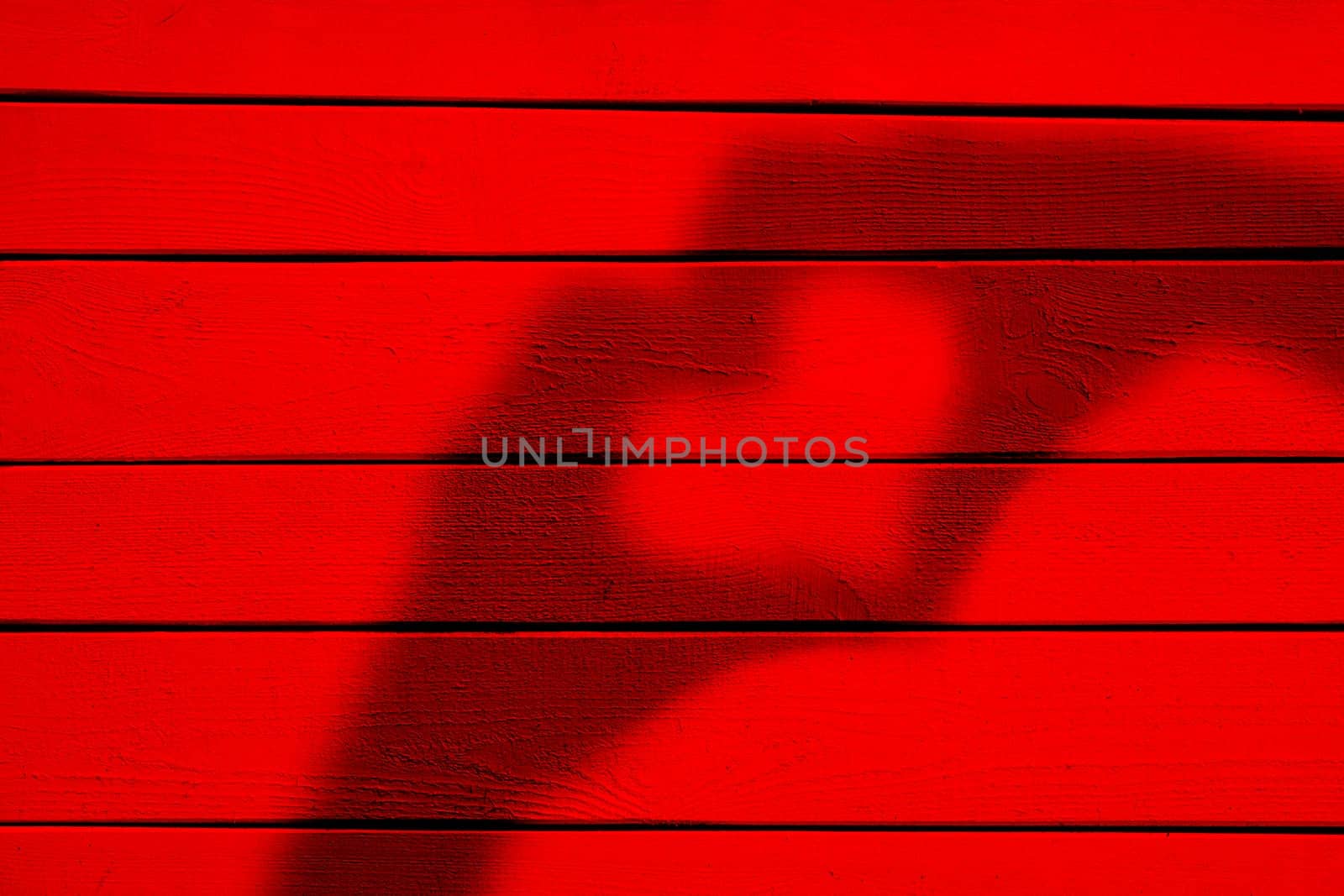 Two hands forming a heart shadow on red wood background by andreyz