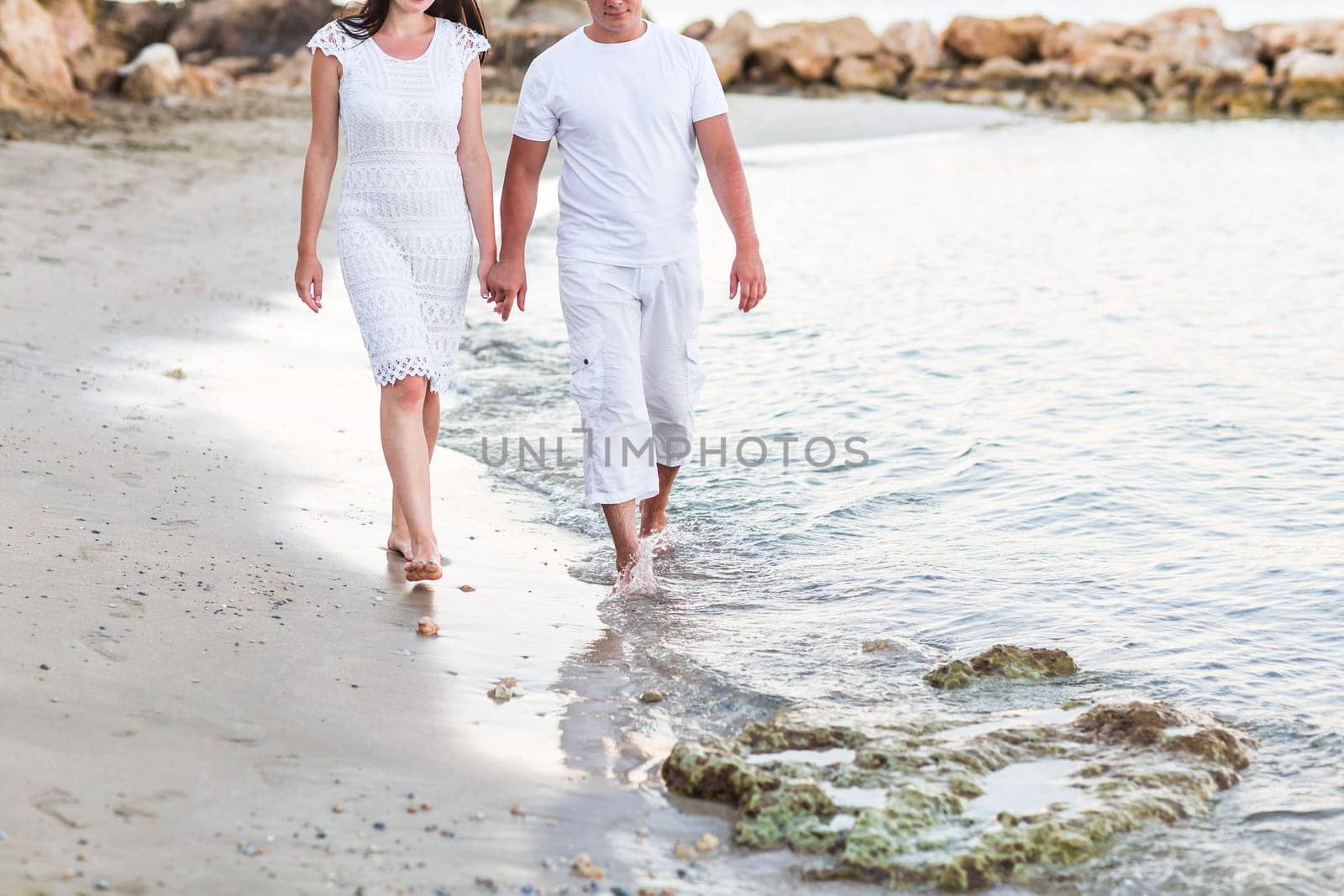 Happy couple walking together along the beach