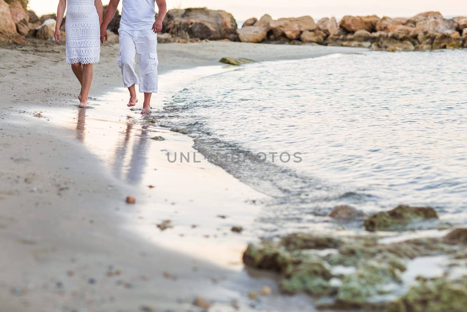 Happy couple walking together along the beach