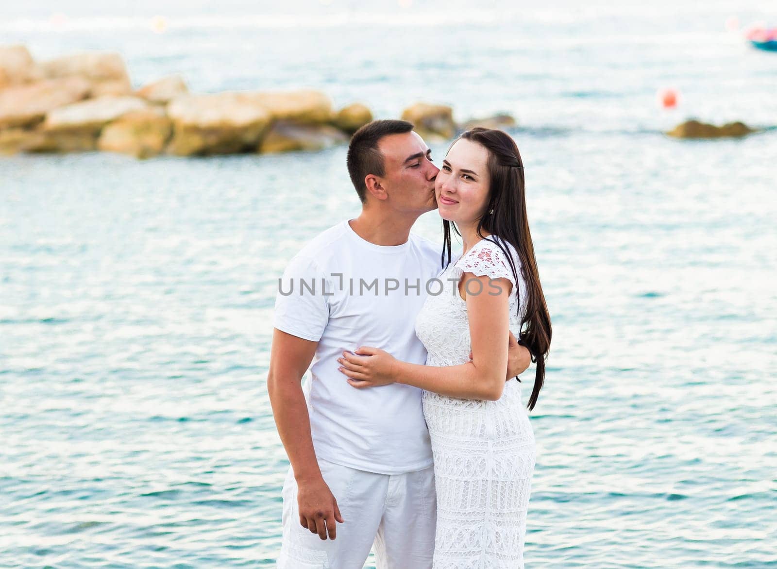 Happy couple walking together along the beach