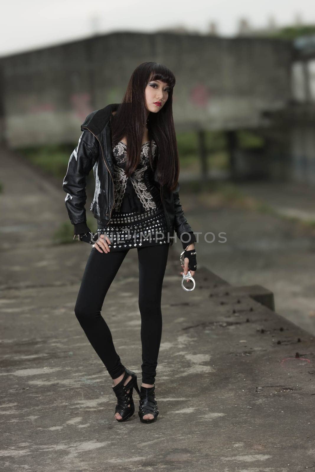 Asian American woman in emo goth clothing at an abandoned building