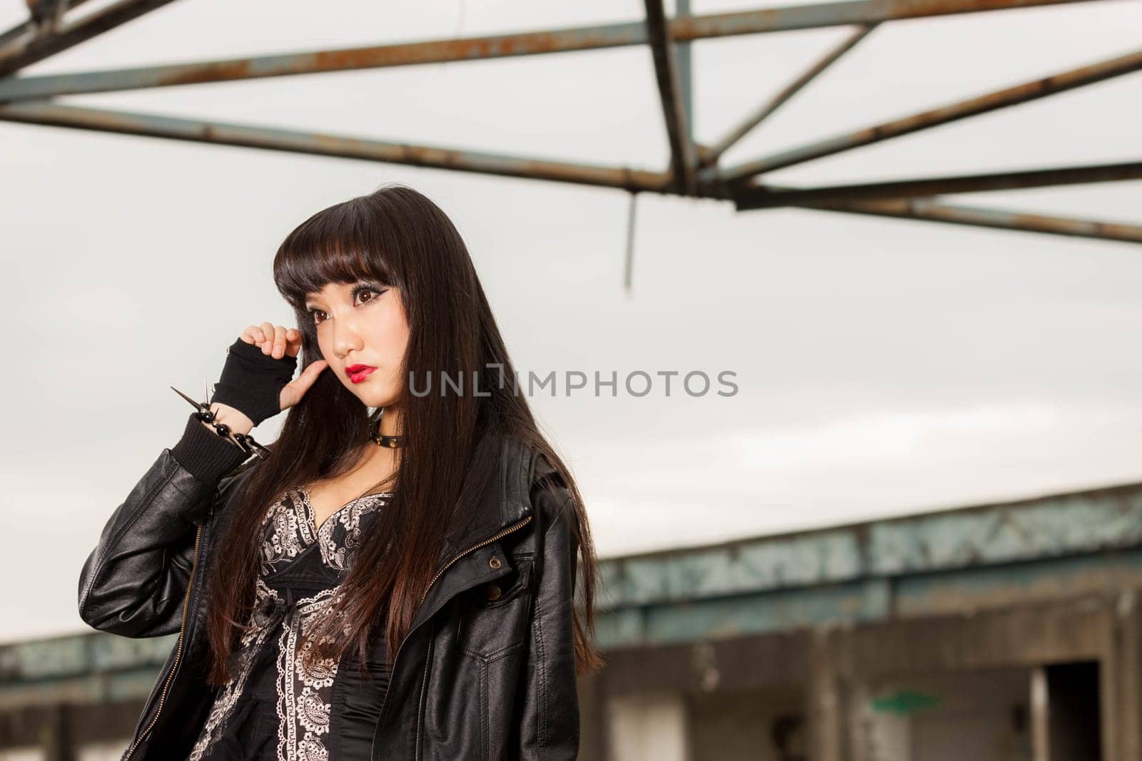 Asian American woman in emo goth clothing at an abandoned building