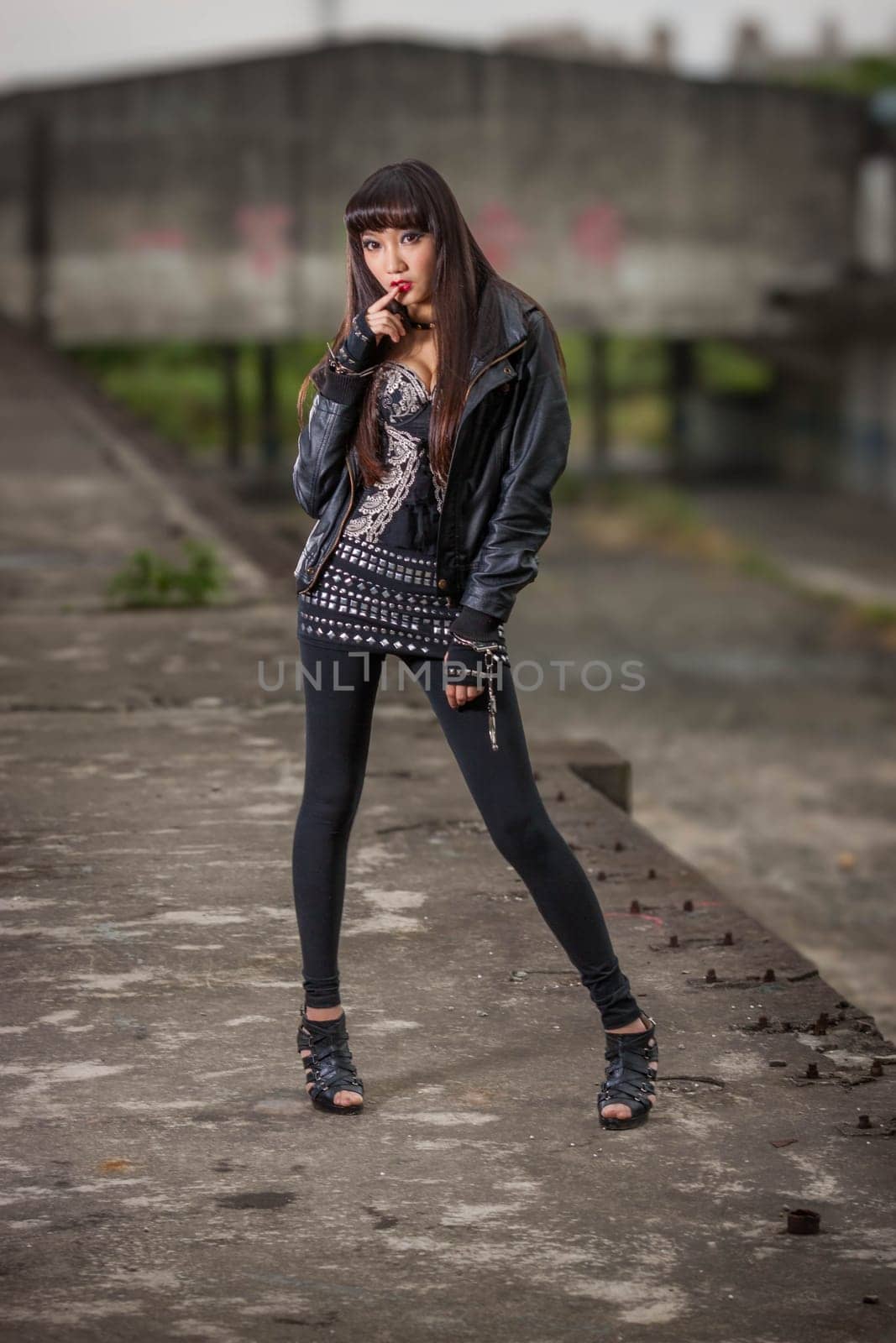 Asian American woman in emo goth clothing at an abandoned building