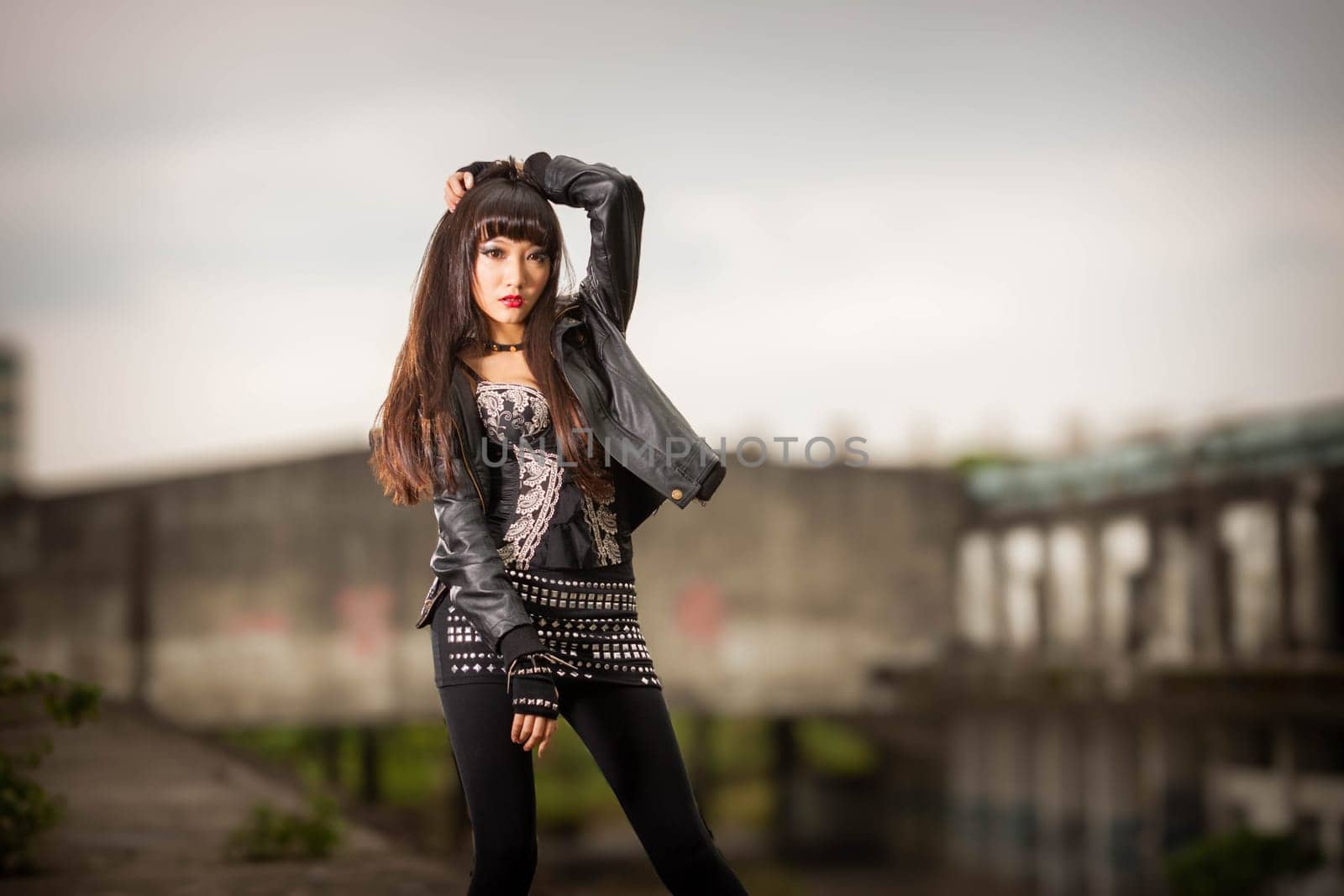 Asian American woman in emo goth clothing at an abandoned building