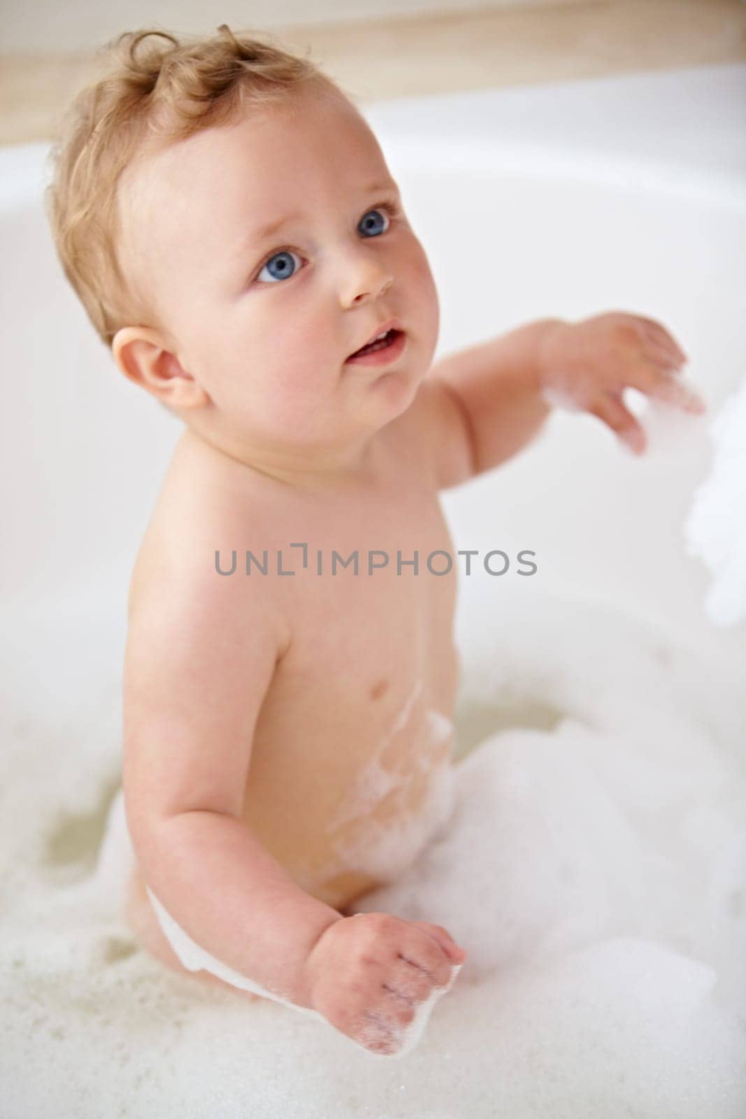 Baby, bubbles and bath or water cleaning for skin or hair wash for childhood development, hygiene or soap. Child, boy and tub for relax wellness or wet in home for play or cleansing, foam or sanitary by YuriArcurs