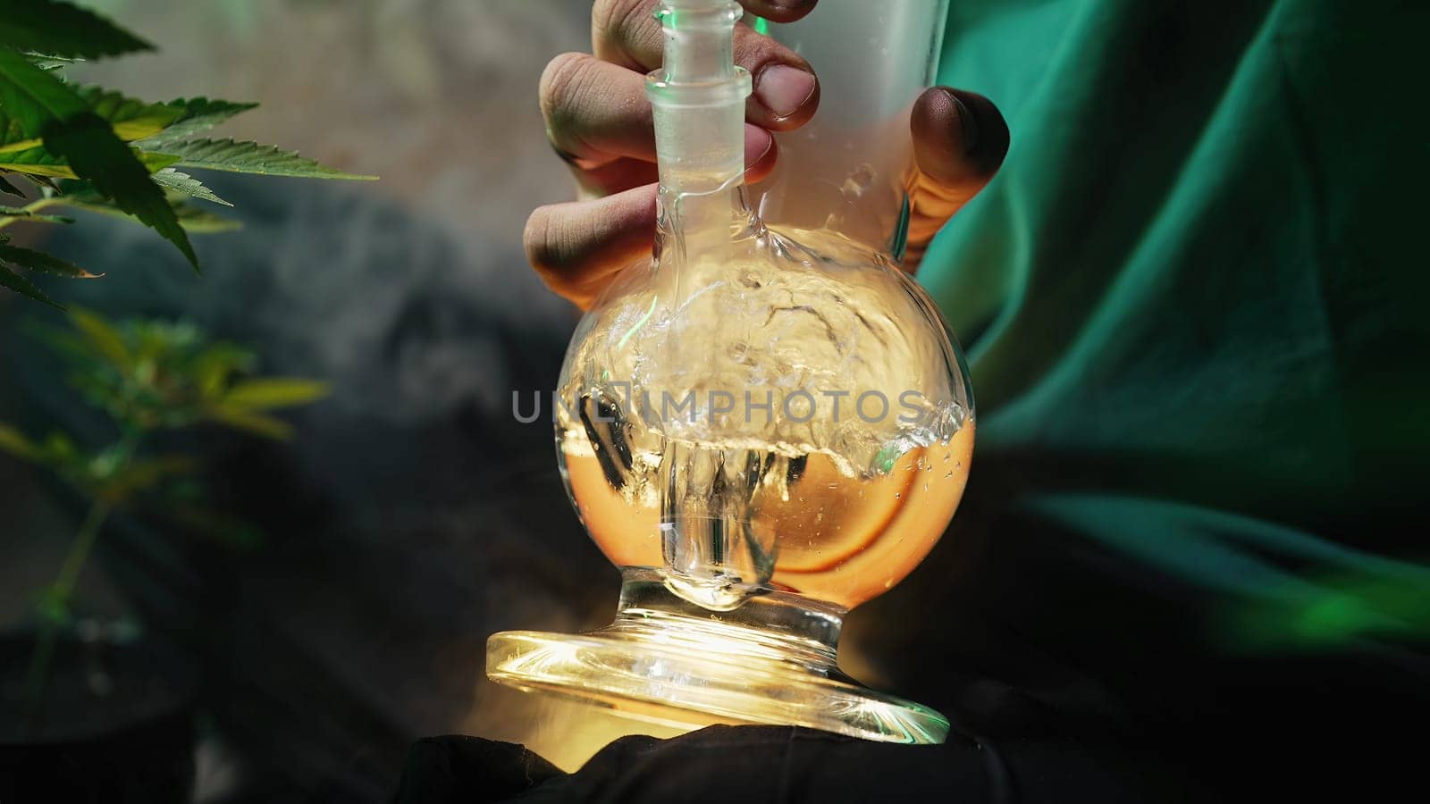 Smoking medical marijuana, glass water bong in neon light at home. Cannabis. High quality photo