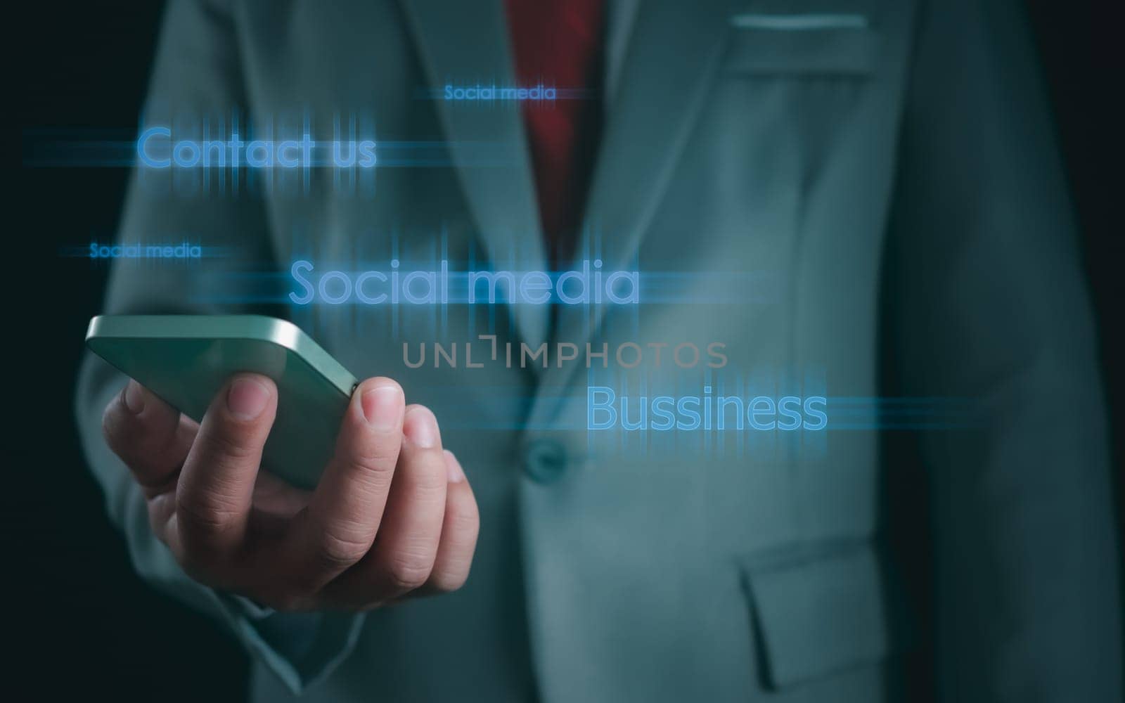 Close-up shot of businessman holding smartphone on dark background Represents business communication concepts.