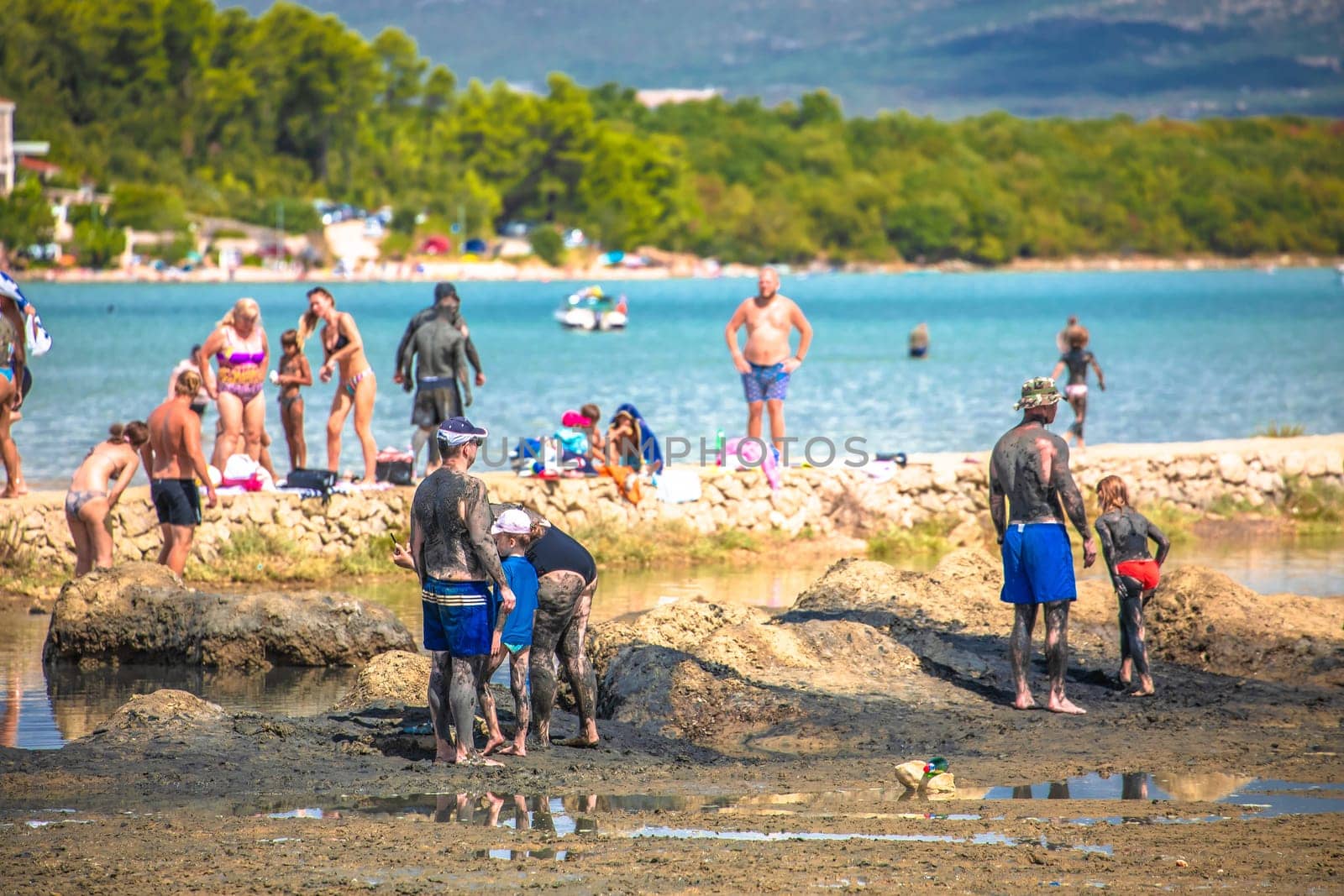 Krk island, Croatia, August 20 2022: Healthy mud beach in Klimno summer view, Soline bay on Krk island, Croatia. Famous beach wellness spot for many tourists.