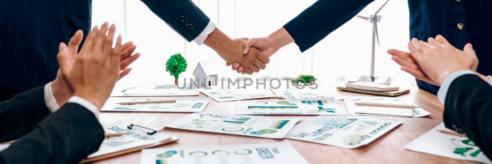 Business people hand shake in Eco corporate meeting room after made successful agreement deal on eco-friendly products. Sustainability and environmental protection in business cooperation.Trailblazing