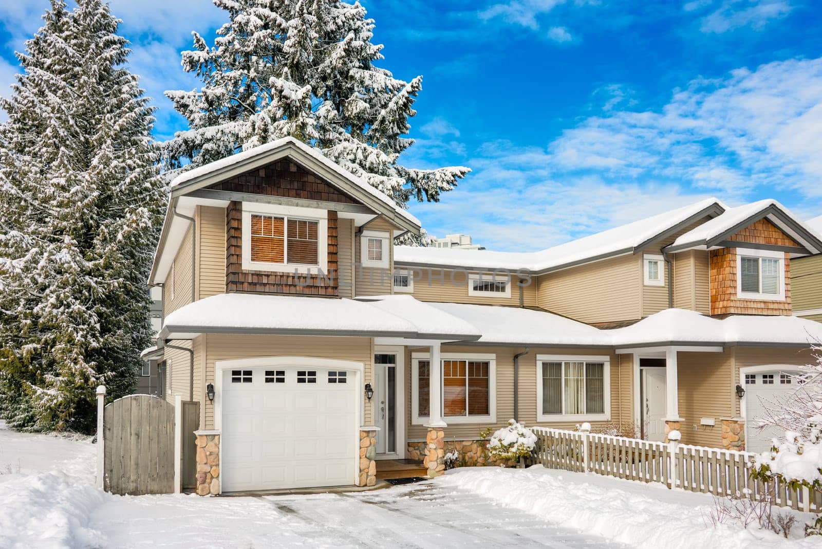 Entrance of residential duplex house with driveway in snow. Winter season in Canada