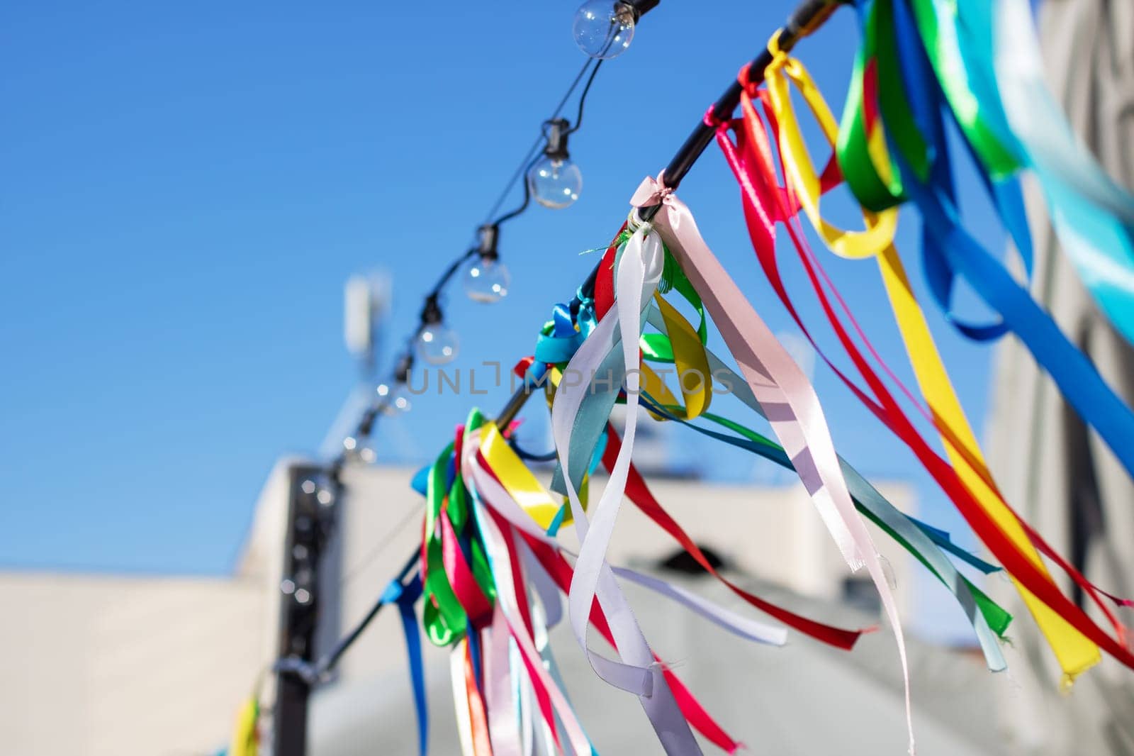 Colorful ribbons on a rope on the background of the blue sky