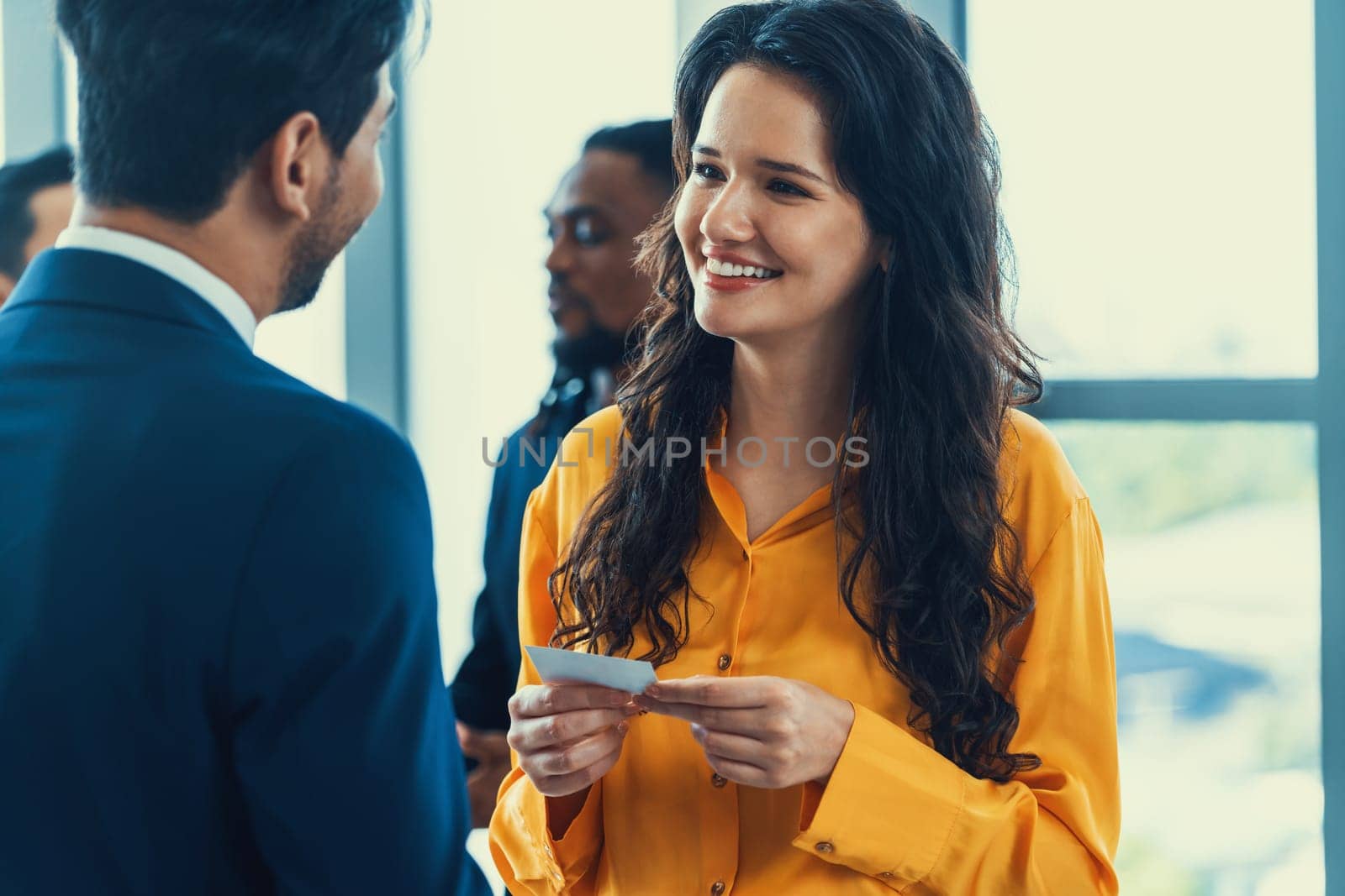 Successful businesswoman holding the name card during talking to manager about their cooperation. Female leader looking businessman during hold his name card admirably. Intellectual.