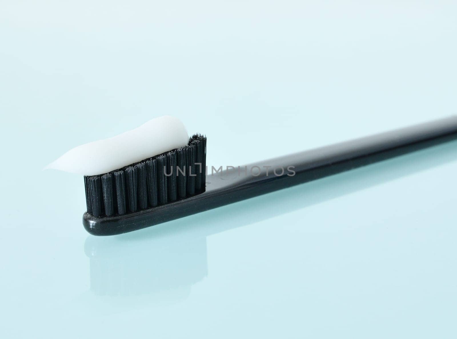 Toothbrush and toothpaste on light blue background