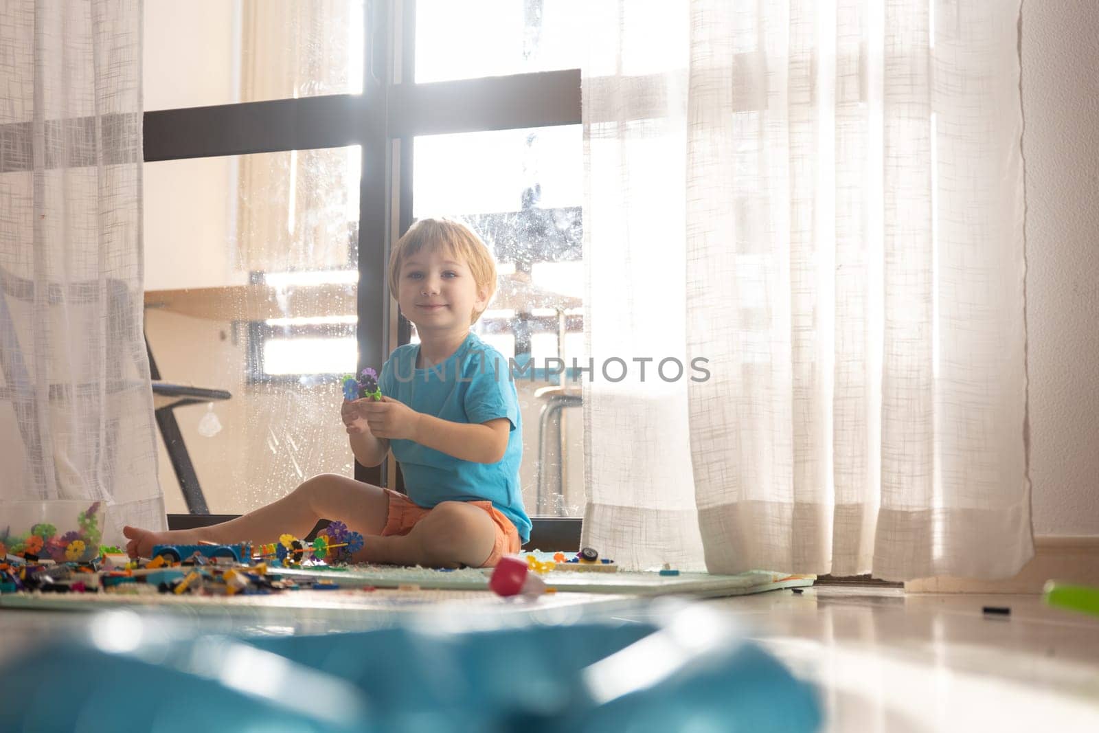 A little boy sitting on the floor playing with toys