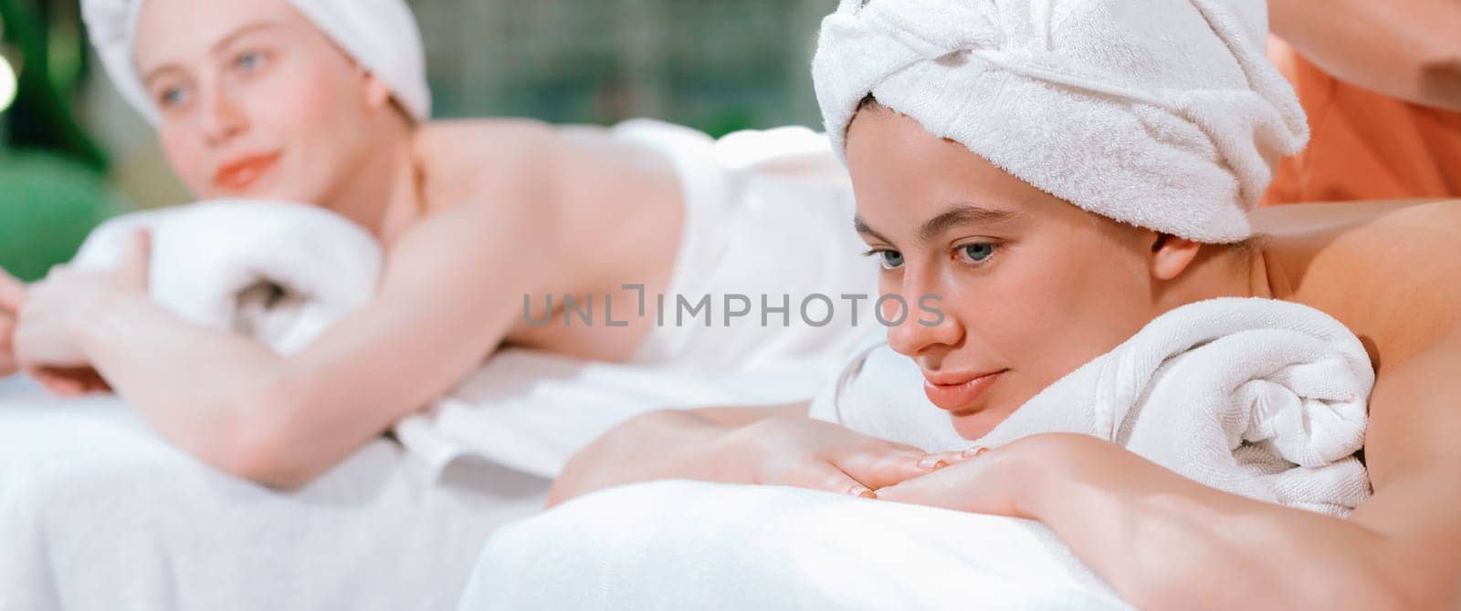 A portrait of a couple of attractive young woman lie on spa bed. Tranquility. by biancoblue