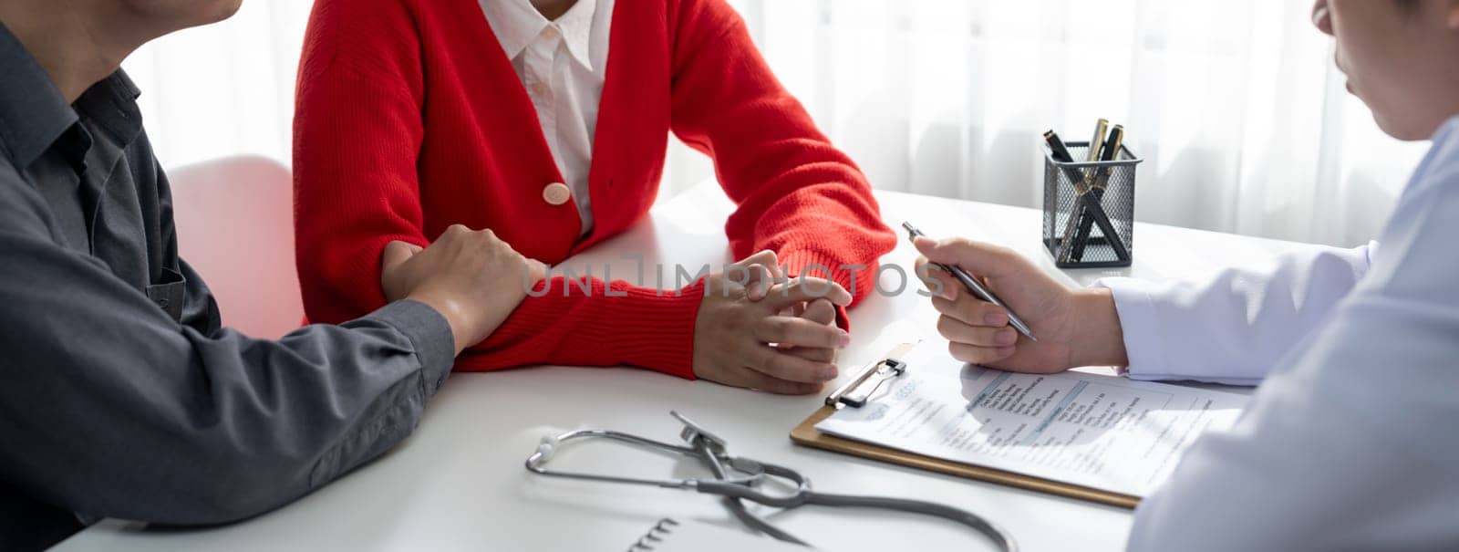 Couple attend fertility or medical consultation with gynecologist at hospital as family planning care for pregnancy. Husband and wife consoling each other through doctor appointment. Panorama Rigid