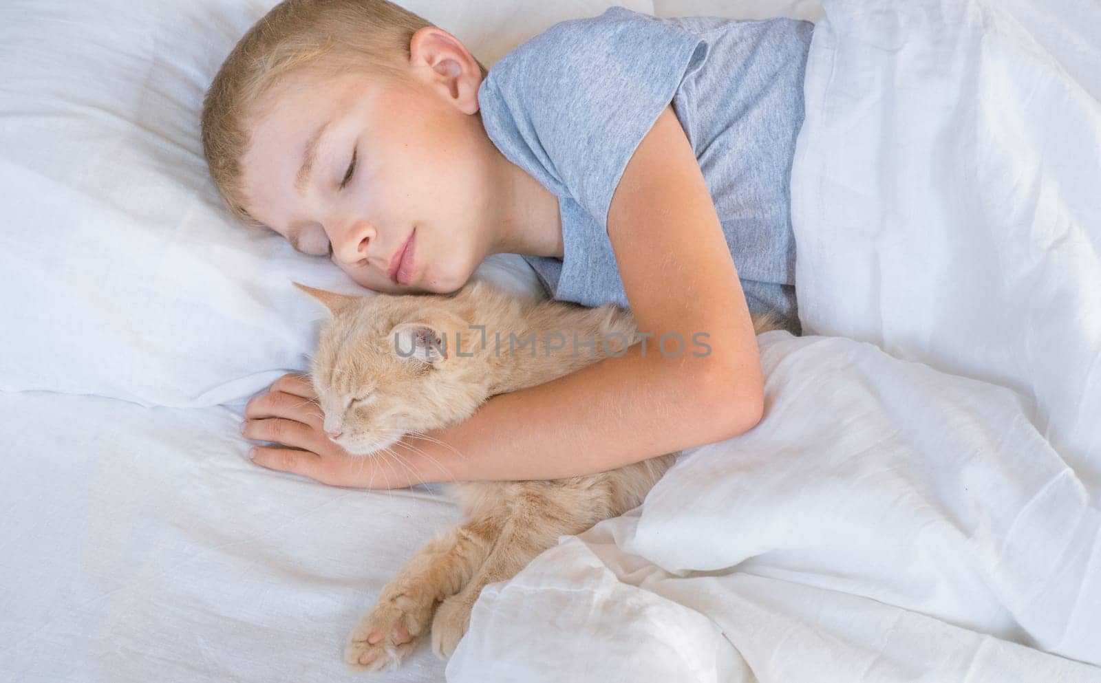 A child in bed cannot fall asleep, yawns, grimaces and plays with a ginger cat