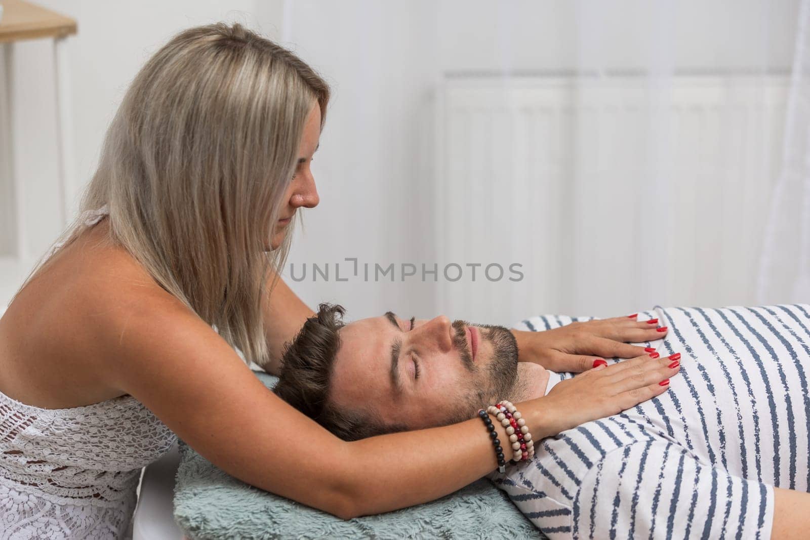 Woman healer performing access or conciousness bars to a man, alternative medicine concept