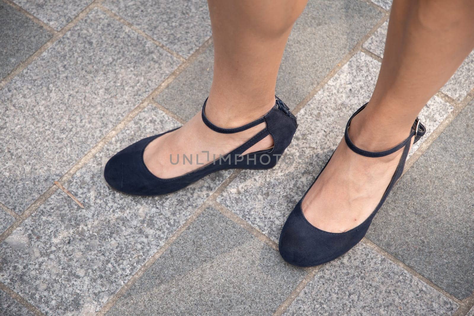 beautiful female tanned legs in dark blue strappy shoes, retro fashion for walking around the city, sexy shoes, High quality photo