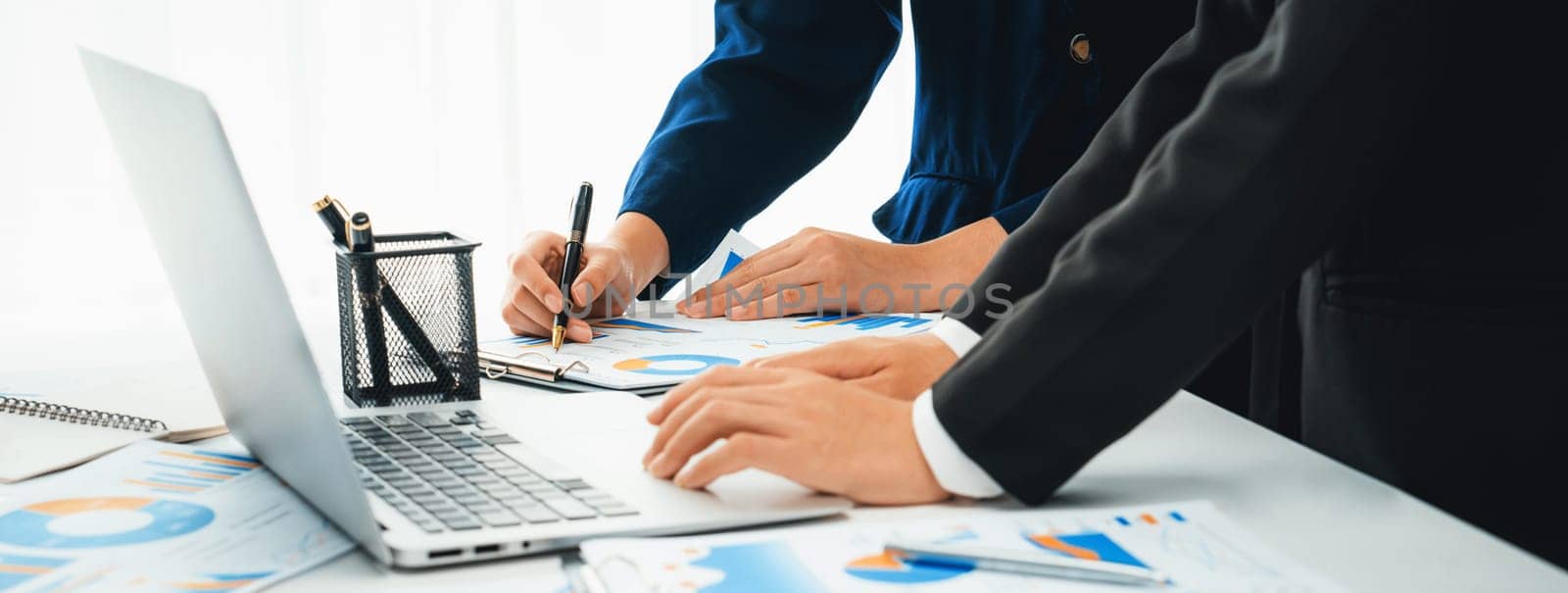 Business people in group meeting in formal attire share idea discussing report for company profit in creative workspace for start up business shot in close up view on group meeting table . Oratory .