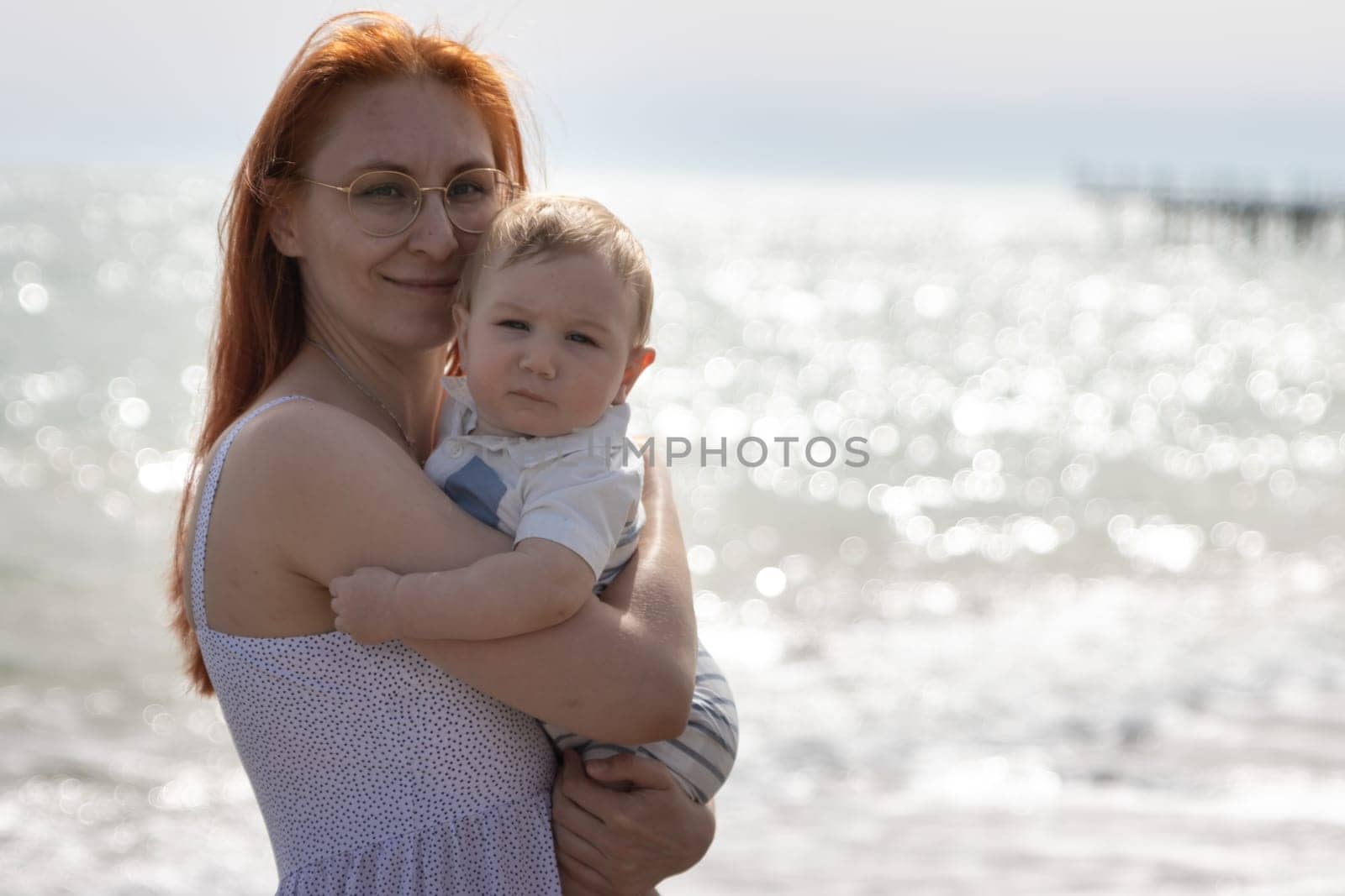 Happy mother on vacation - woman hugging her little baby son by Studia72