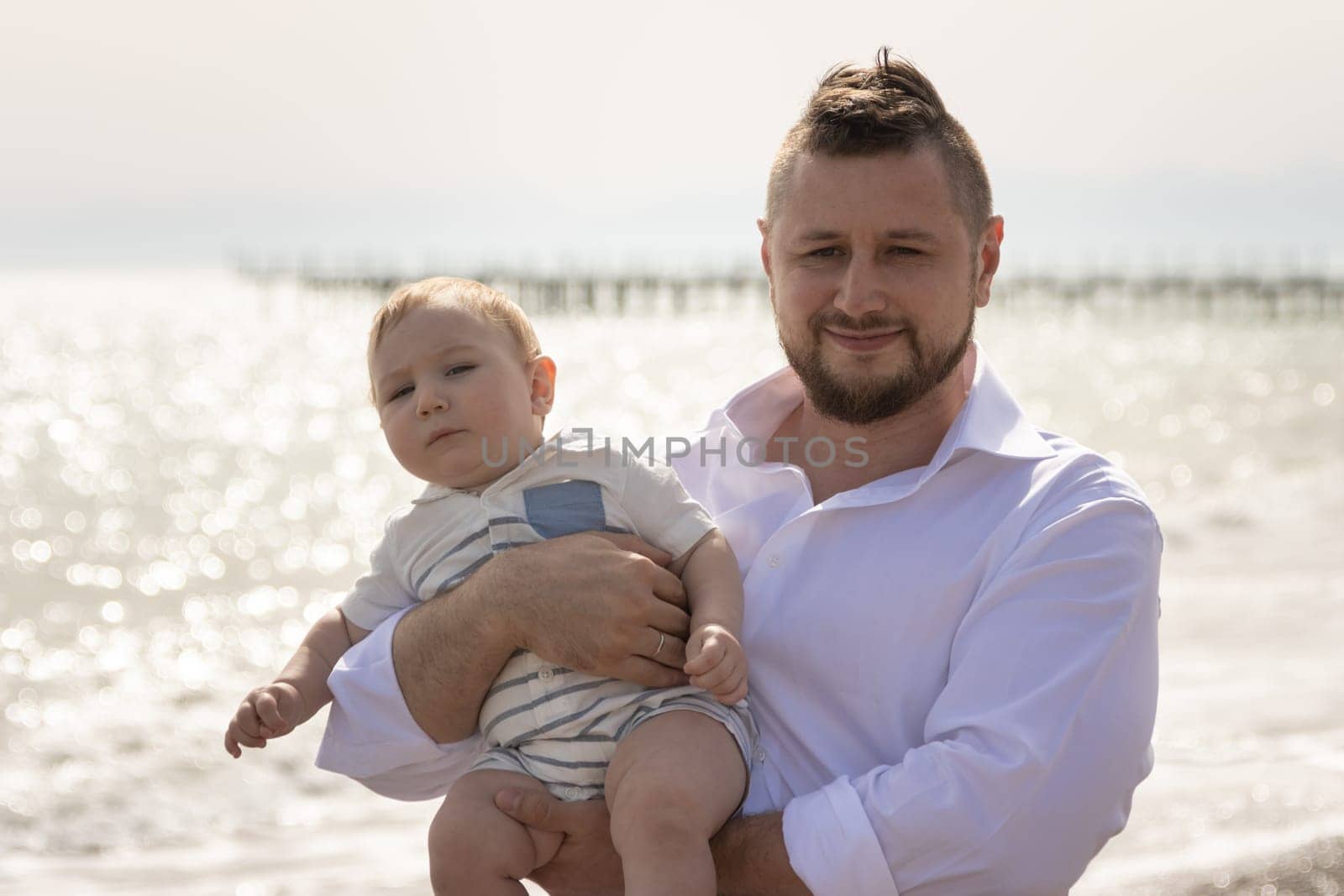 Happy father on vacation - man hugging his little baby son. Portrait