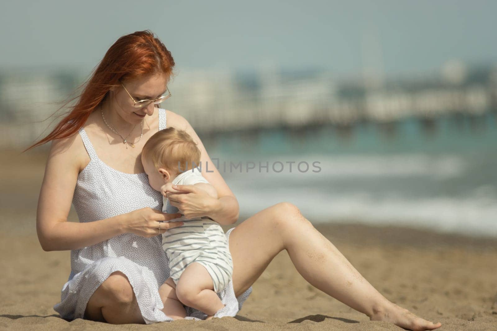 Mother and her little son resting on the seaside. Mid shot