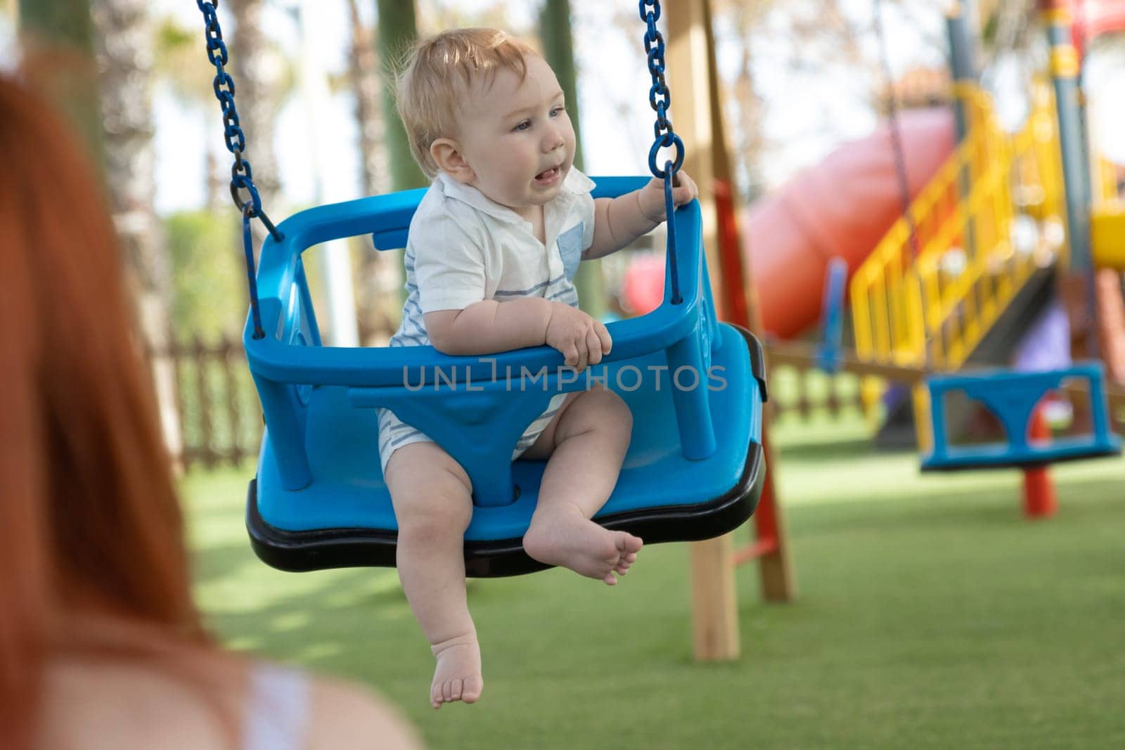 A little boy on swings on an outside playground by Studia72
