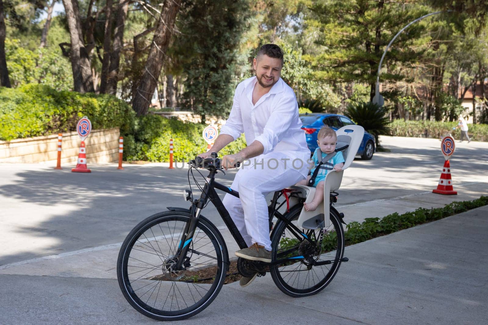 Father with his son on the back riding a bicycle. Mid shot