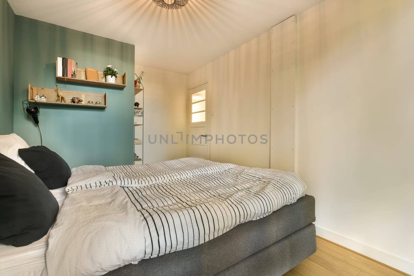 a bedroom with a bed and shelves on the wall next to the bed, there is a lamp above the bed