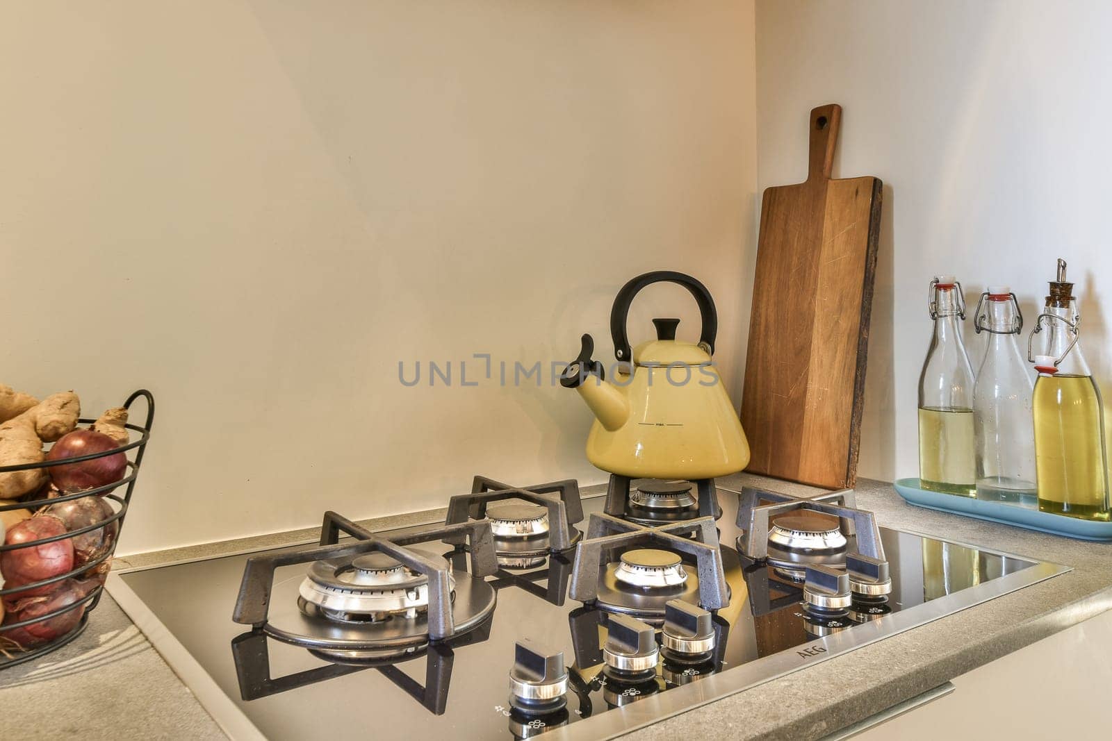 a kitchen with pots and kettles on the stove top, next to a bowl of fruit sitting on the counter