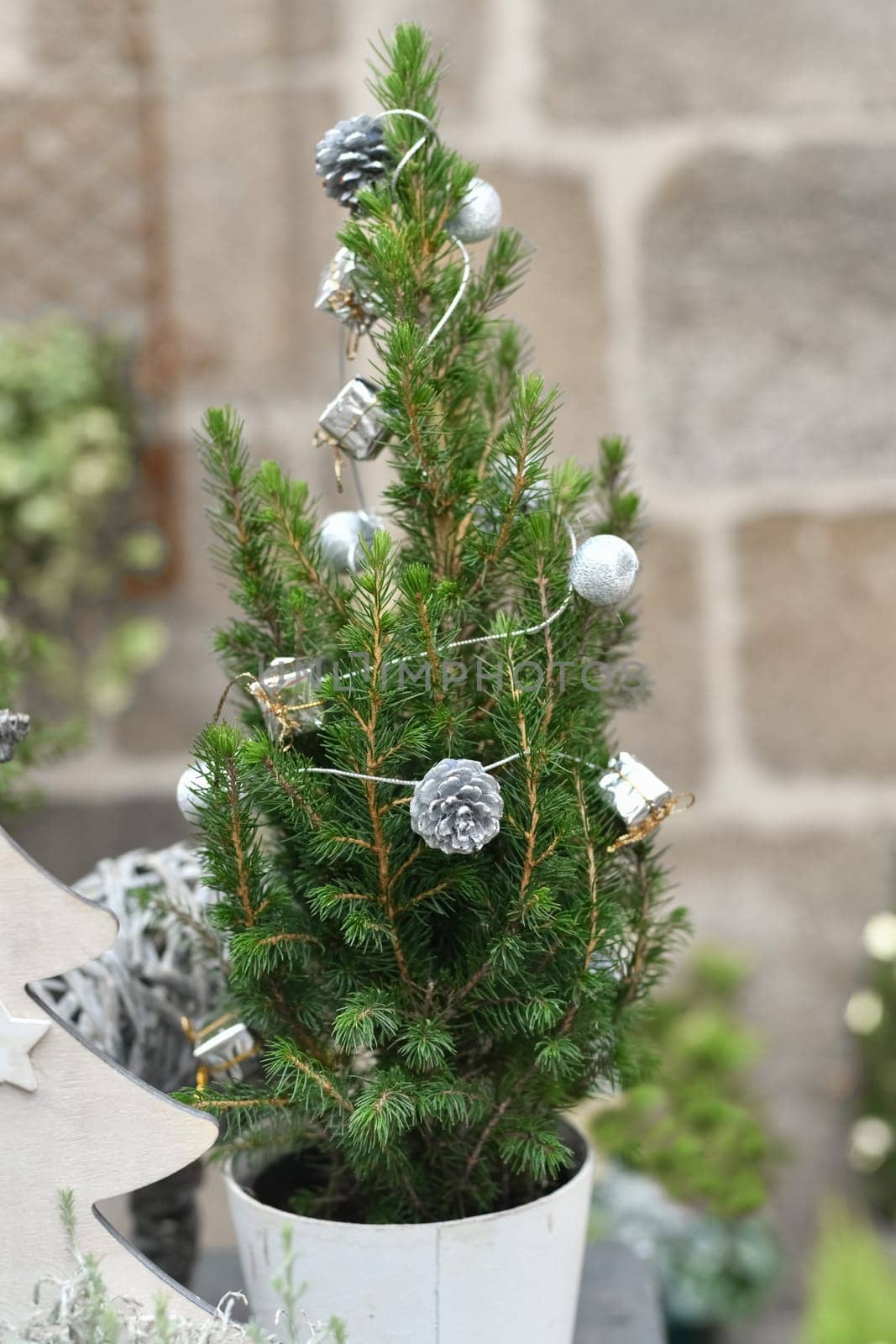 Decorated Christmas tree in a white pot in a shop
