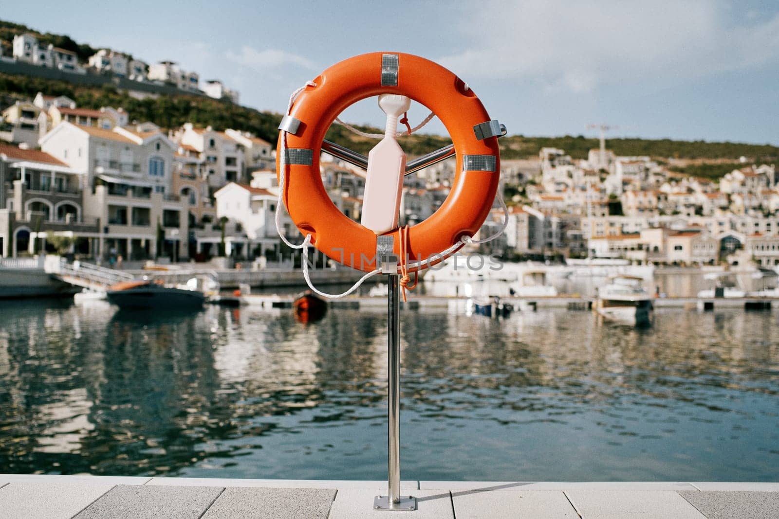 Lifebuoy on a stand with a latch stands on a pier in Lustica Bay. Montenegro. High quality photo