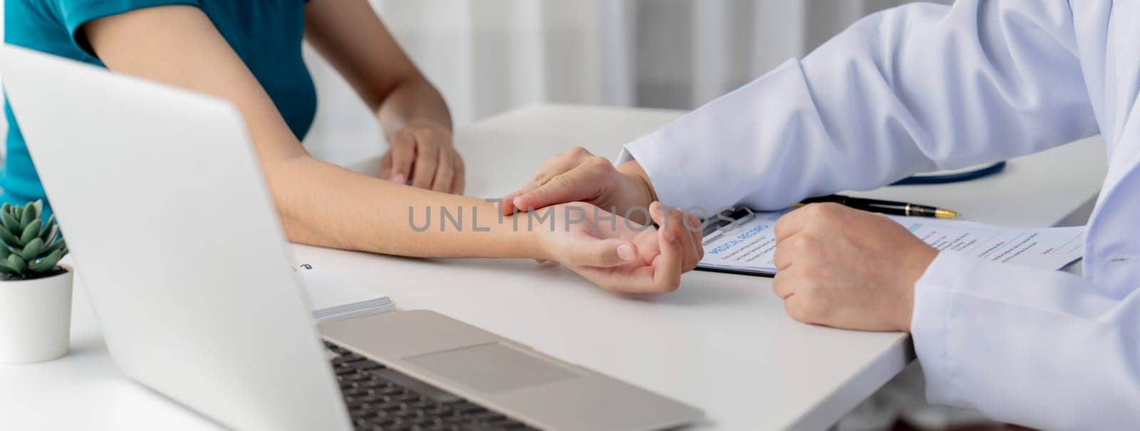 Patient attend doctor's appointment at clinic or hospital office. Doctor discusses medical treatment option, examining and diagnosis symptoms while checking the patient's pulse. Panorama Rigid