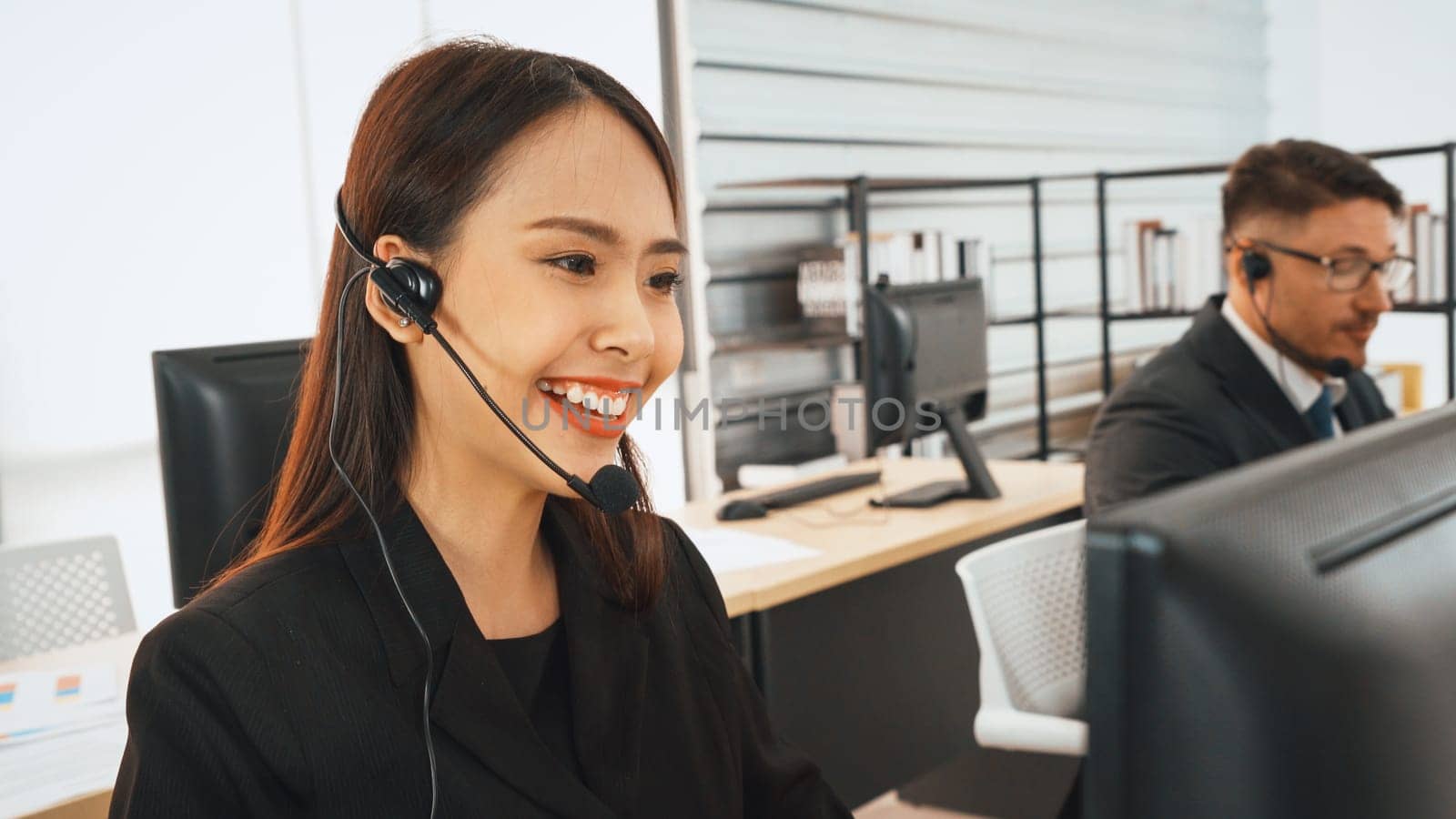 Business people wearing headset working in office to support remote customer or colleague. Call center, telemarketing, customer support agent provide service on telephone video conference call. Jivy