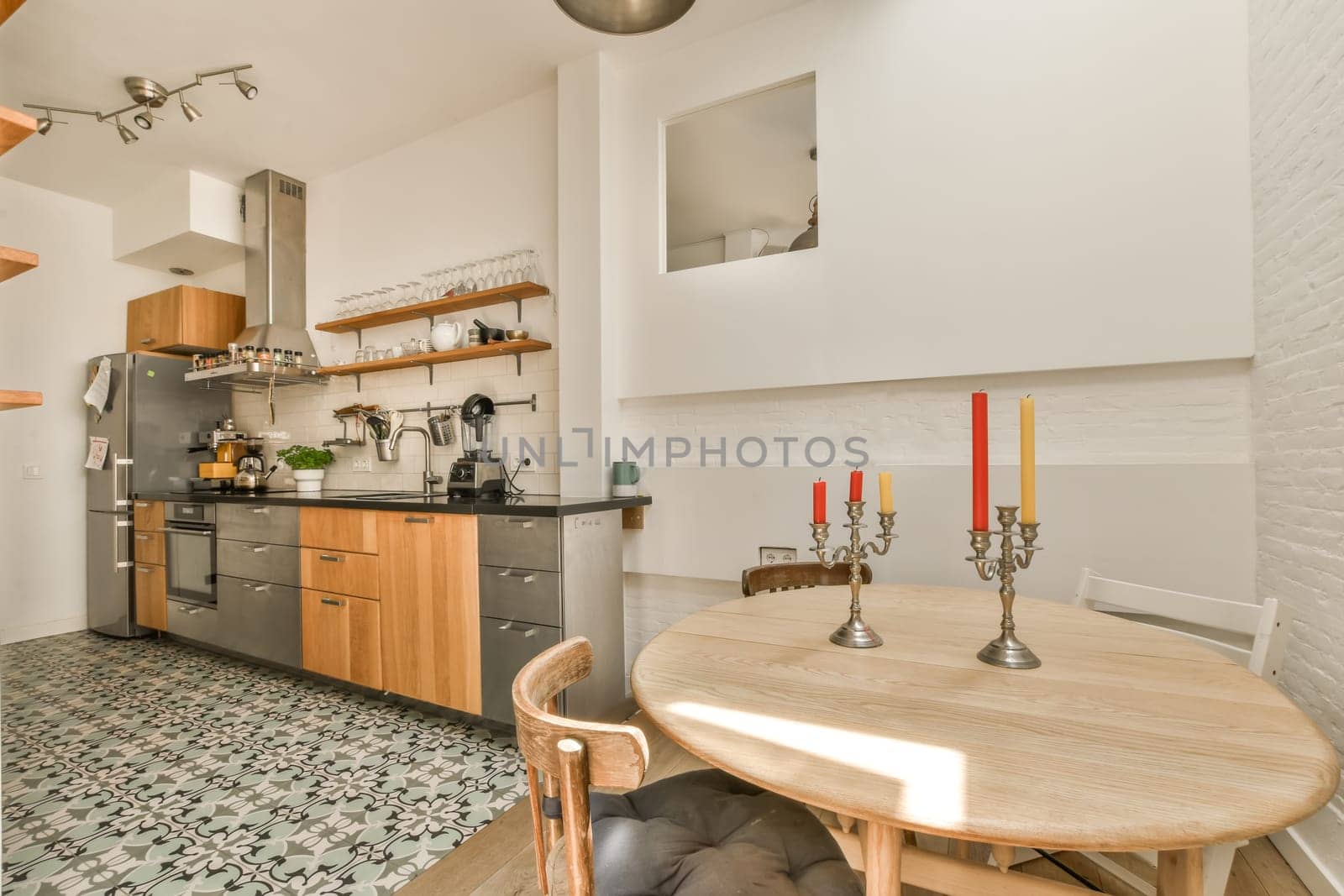 a kitchen and dining area in a small apartment with wood cabinets, tile flooring and stainless appliances on the wall