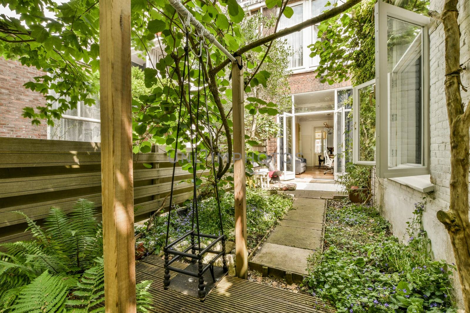 a backyard with a wooden deck and trees and plants by casamedia