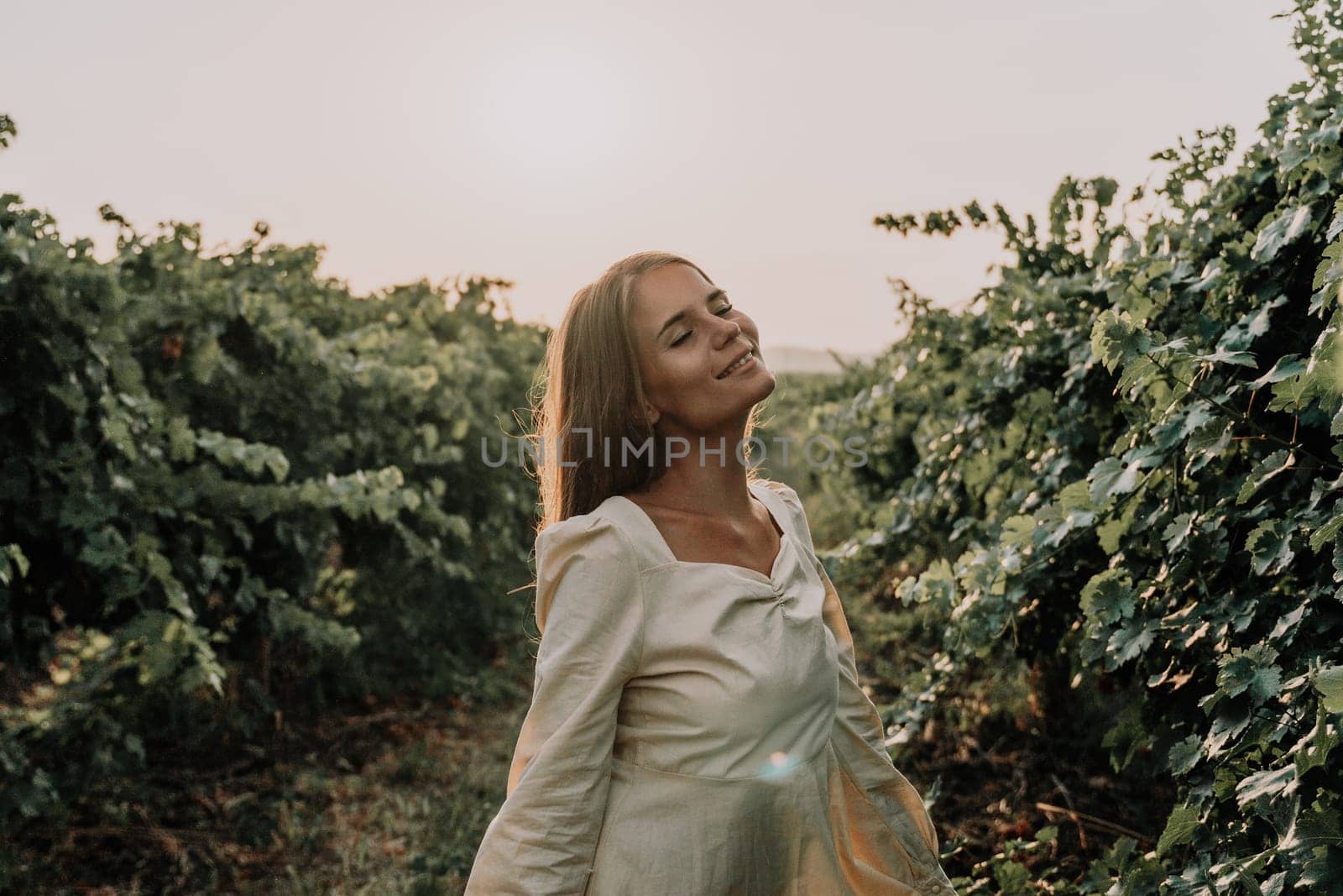 Woman picnic vineyard. Happy woman with a glass of wine at a picnic in the vineyard, wine tasting at sunset and open nature in the summer. Romantic dinner, fruit and wine. by panophotograph