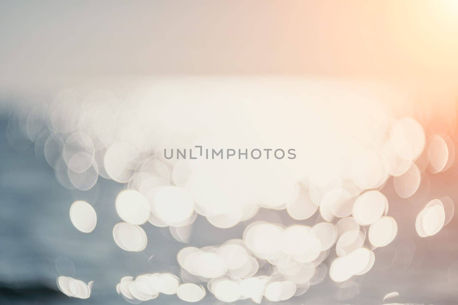 Abstract sea summer ocean sunset nature background. Sound of small waves on golden water surface in motion blur with golden bokeh lights from sun. Holiday, vacation and recreational concept.