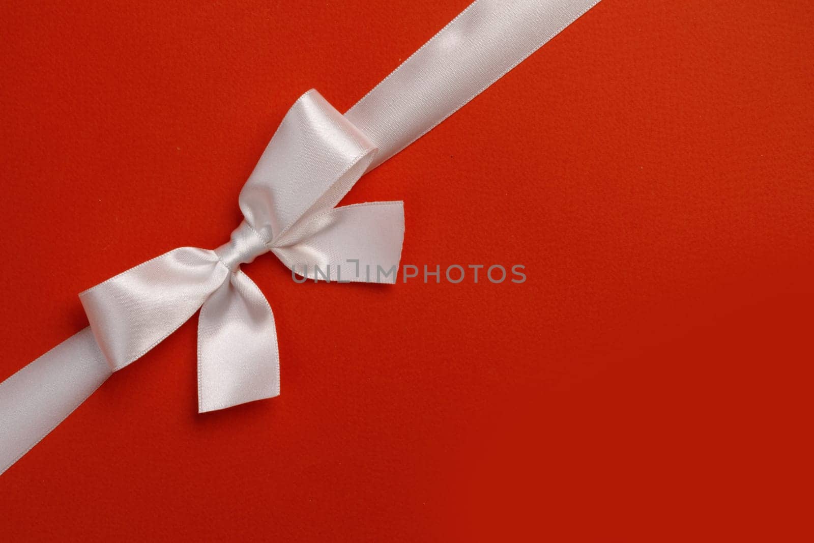 White gift bow on red by Yellowj